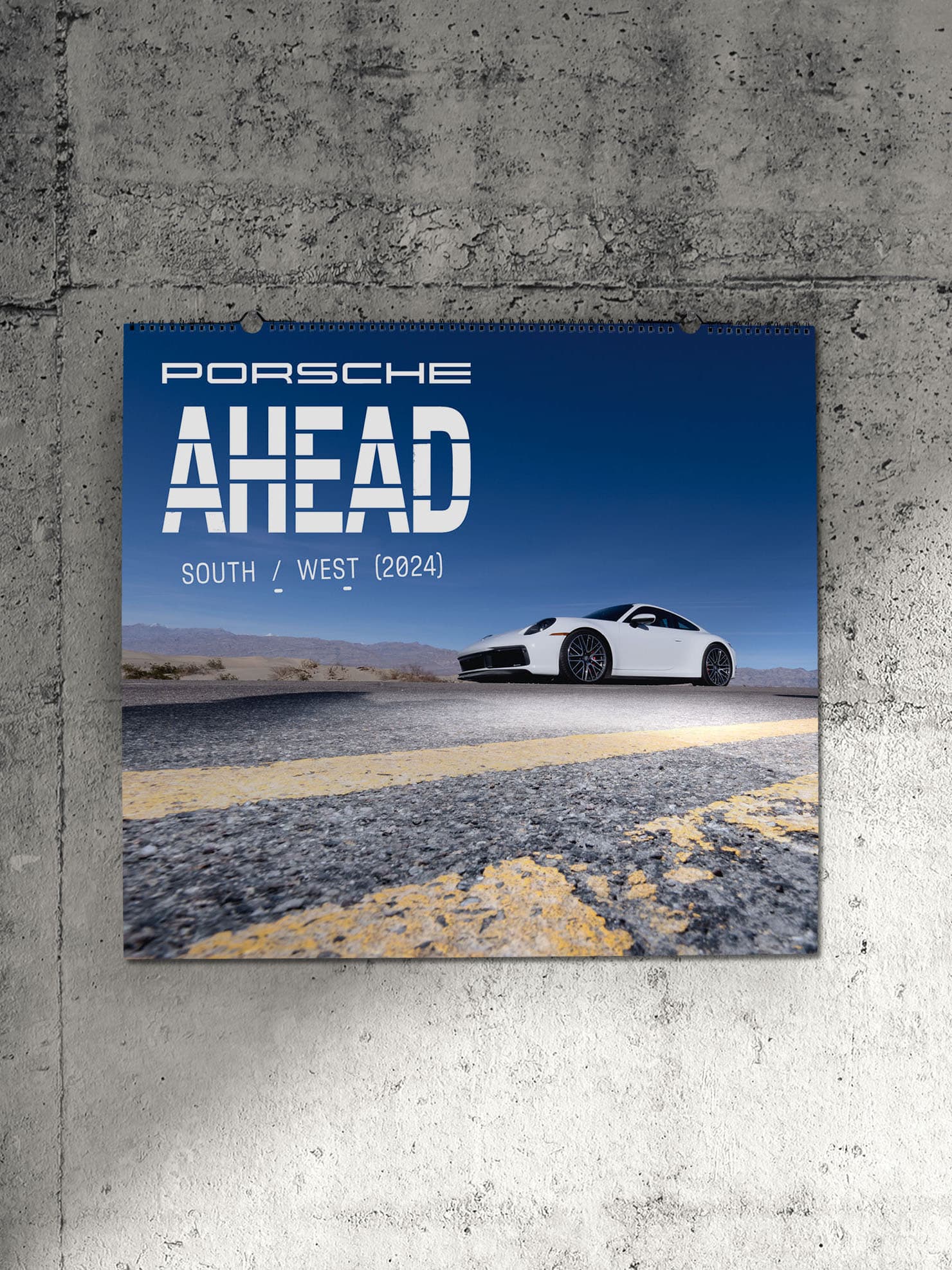 Porsche AHEAD 2024 wall calendar on a stone grey background.