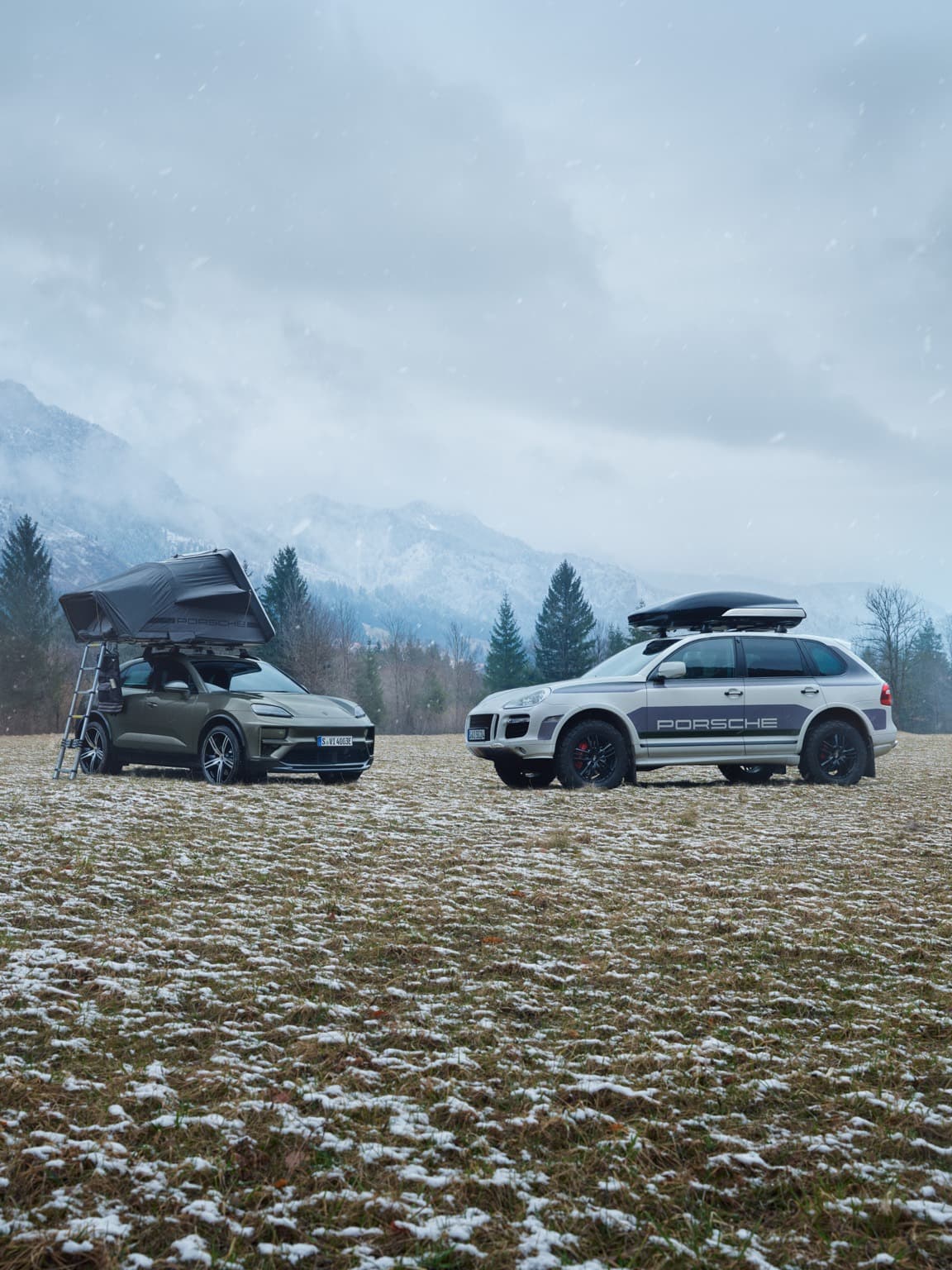 Two Porsche cars next to each other with a roof tent and a roof box