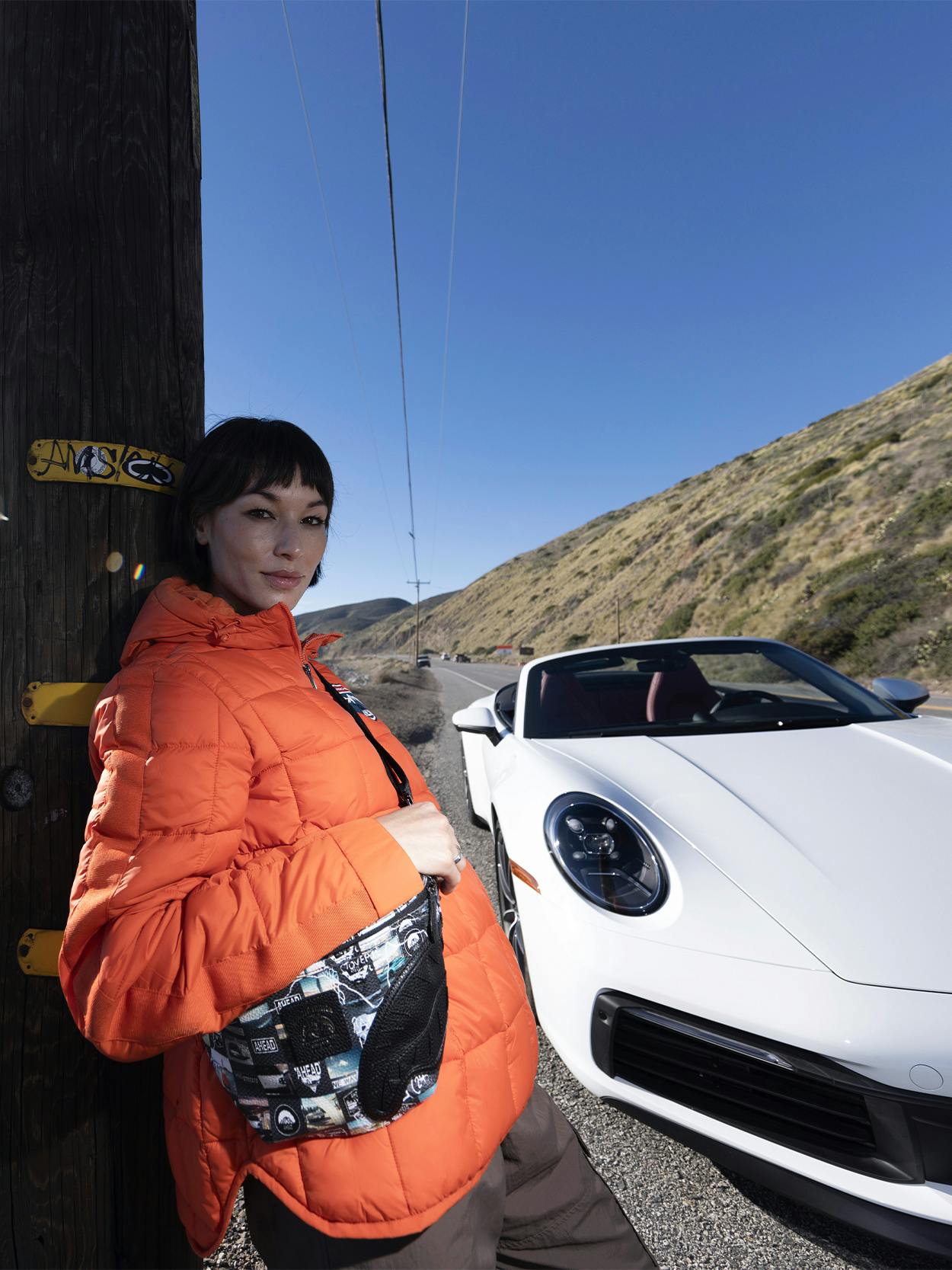 Woman standing next to a Porsche 718