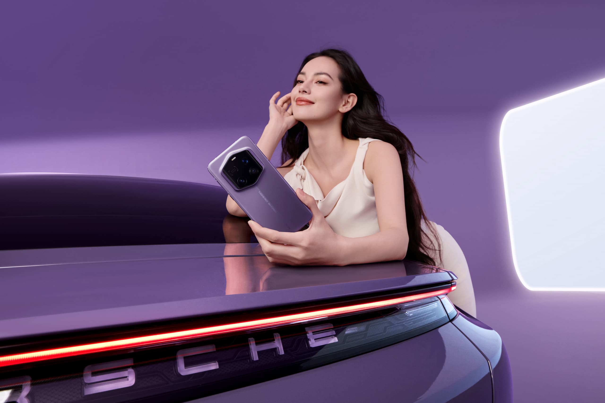 Woman in white dress leans over the rear of a Porsche in the color Provance. In her hand she holds the PORSCHE DESIGN HONOR Magic7 RSR in the color Provence.