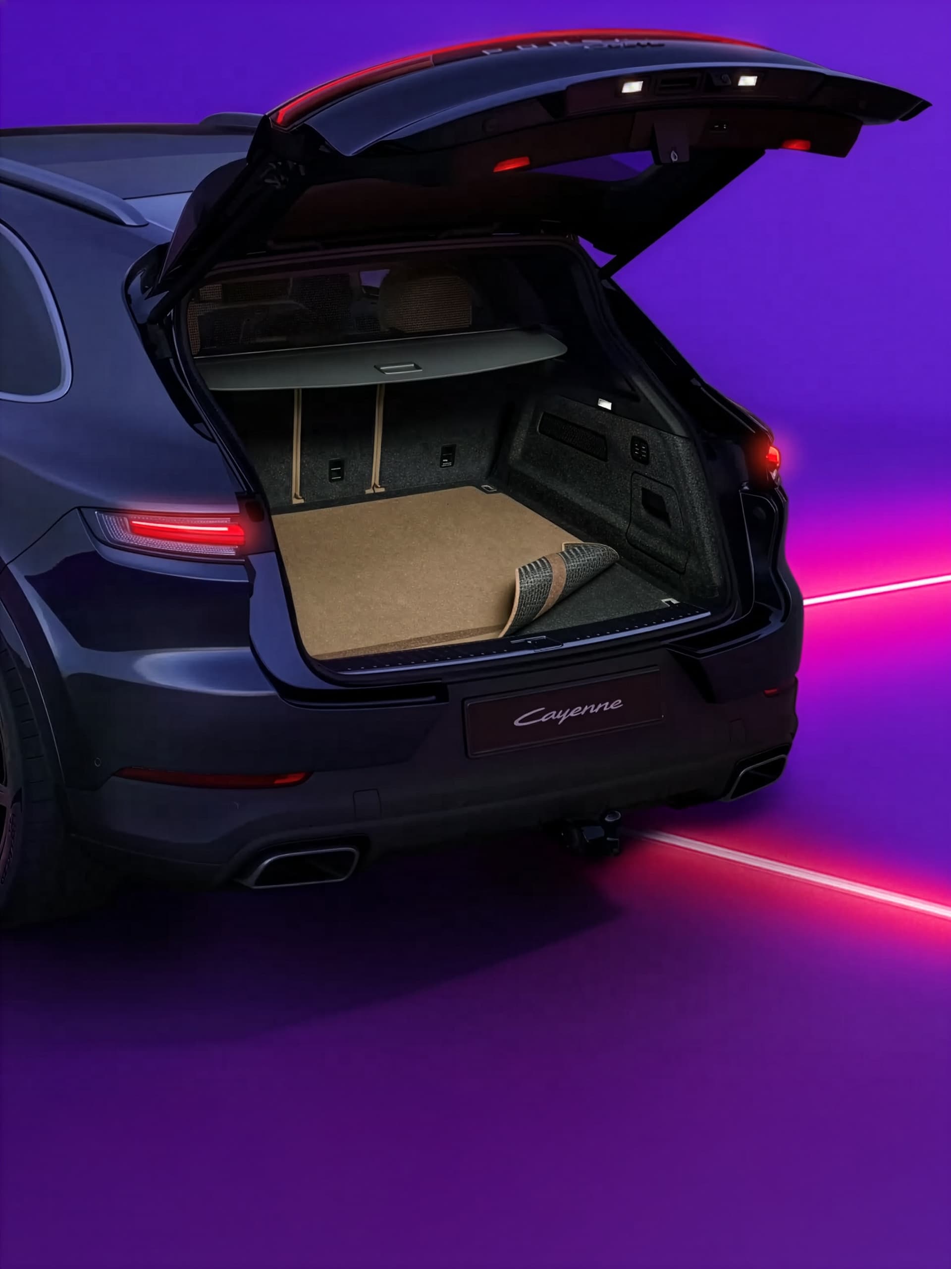 Porsche Cayenne with open trunk on a vibrant purple background, showcasing spacious cargo area with beige mat.
