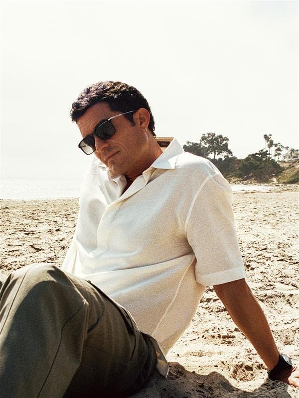 You can see Orlando Bloom sitting at the beach, wearing Porsche Design sunglasses