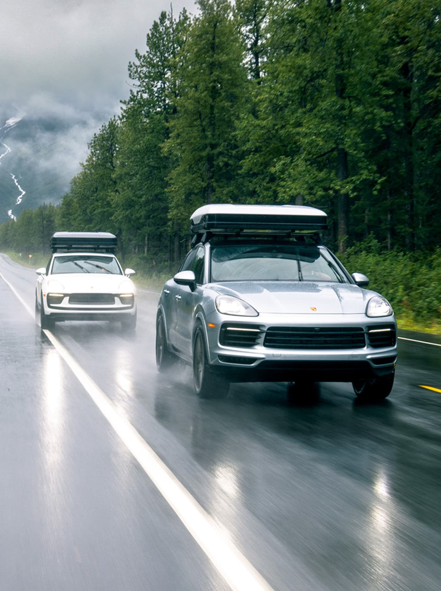 Produktdetailseite:
Zwei silberne SUVs mit Dachboxen auf einer nassen Waldstraße, umgeben von Bäumen und nebligen Bergen.
Kampagnenseite:
Zwei silberne SUVs mit Dachboxen fahren auf einer nassen Waldstraße, umgeben von Bäumen und mystischen Bergen.