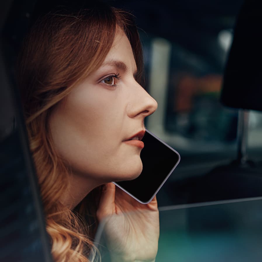 Close-up of woman sitting in a car with the window open and talking on the phone with the PORSCHE HONOR Magic7 RSR