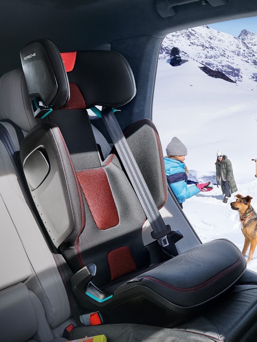 Porsche handleidingen en brochures op een houten tafel met rode mappen, autoafbeeldingen en onderhoudsdocumenten in een werkplaats.