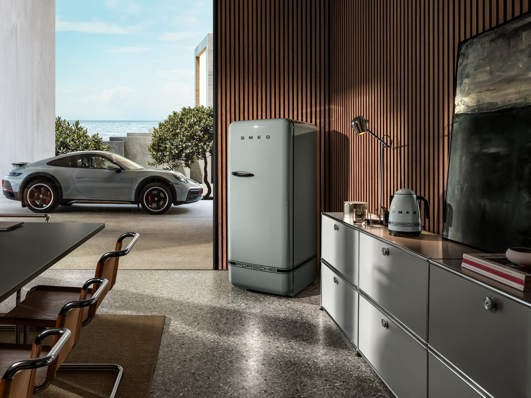 Porsche x Smeg coffee machine in a living room setting with a view of a winter landscape