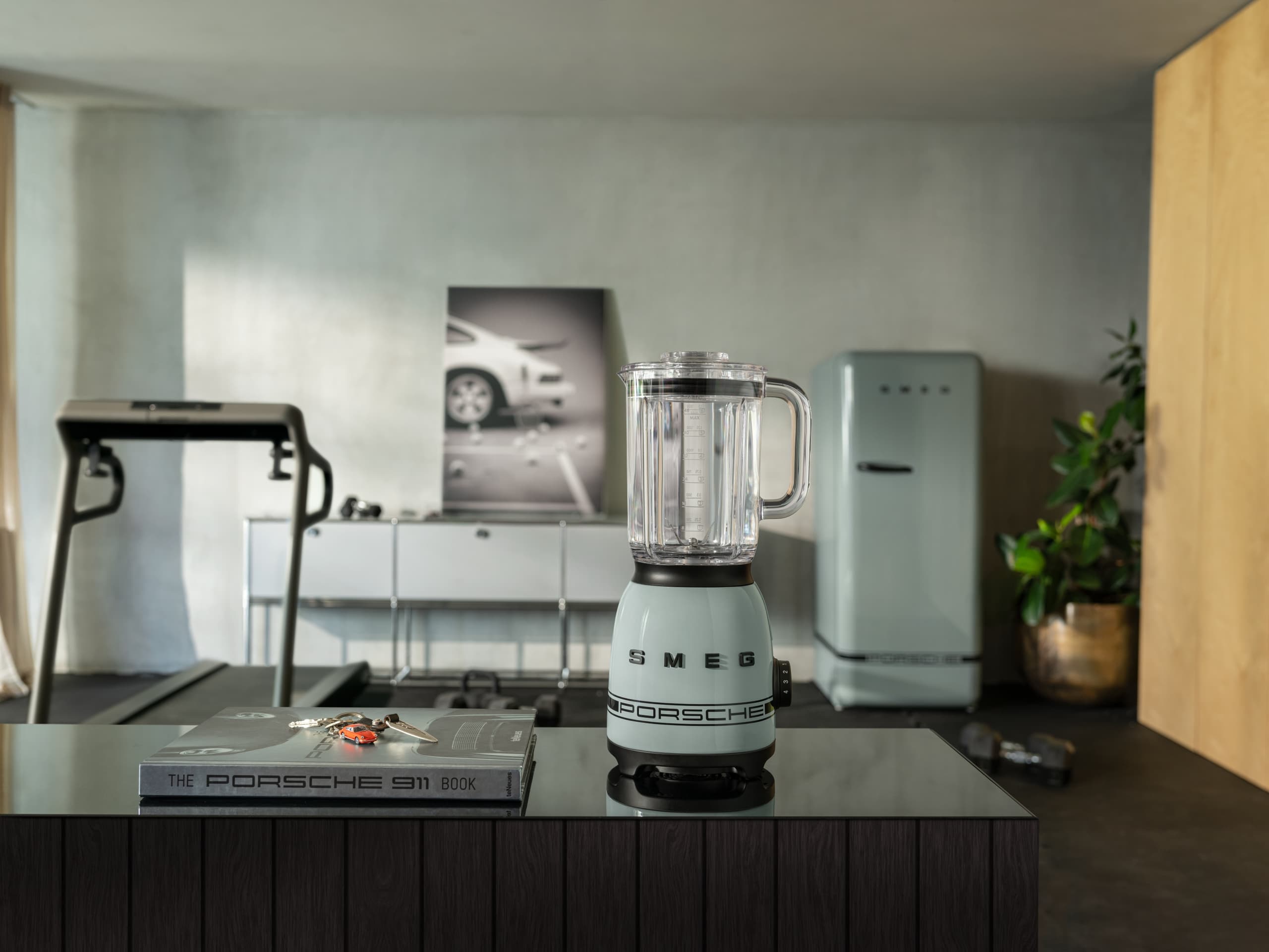 Porsche x Smeg coffee machine in a living room setting with a view of a winter landscape
