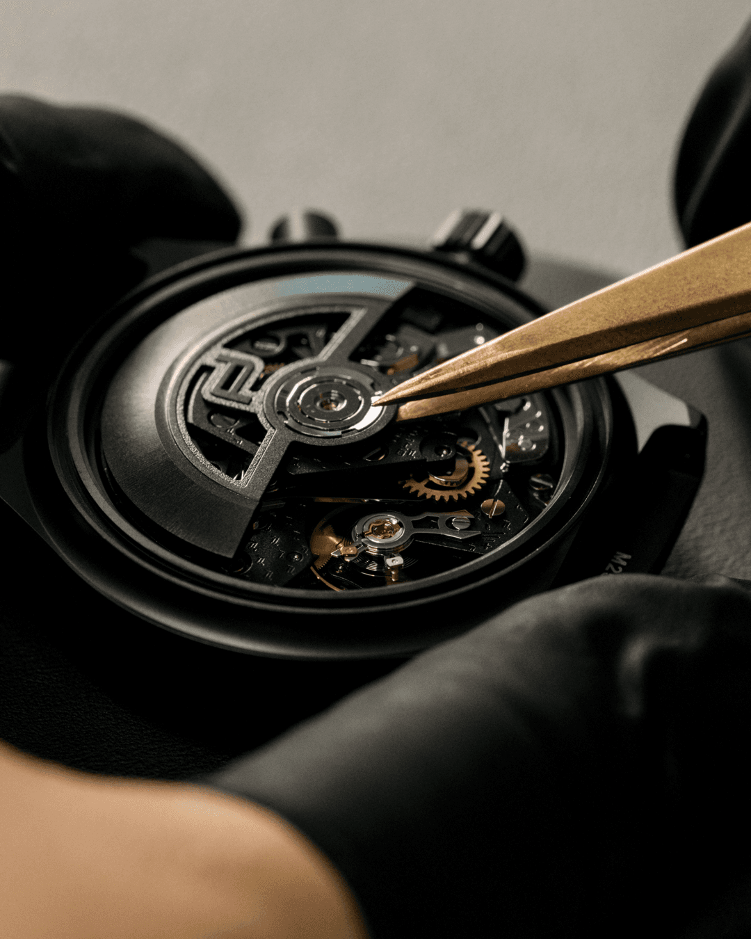 Detail eines Uhrmachers, der das Uhrwerk eines Porsche Design Chronographen justiert