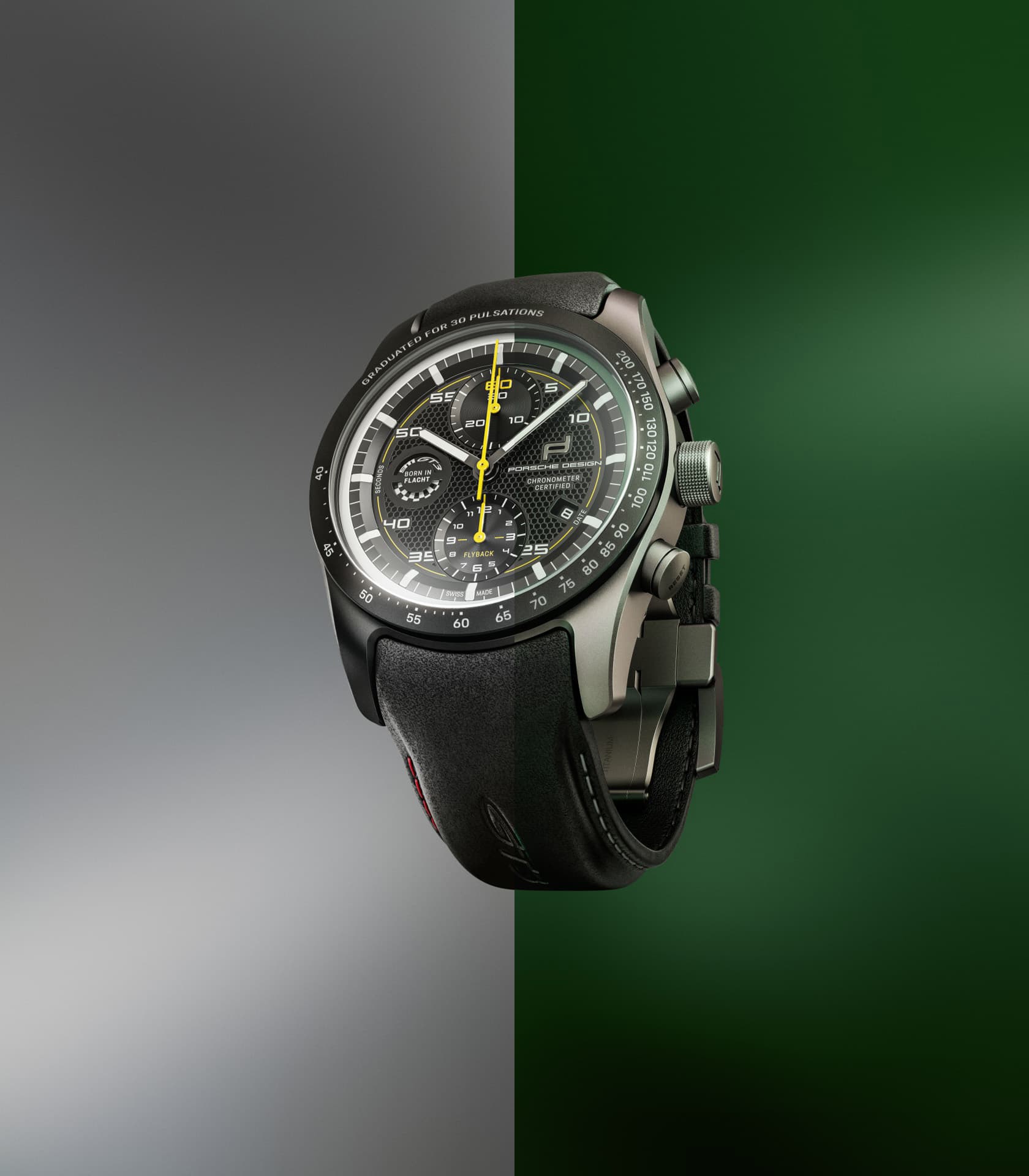 Black chronograph with yellow hands and a black leather strap, set against a gray-green background.