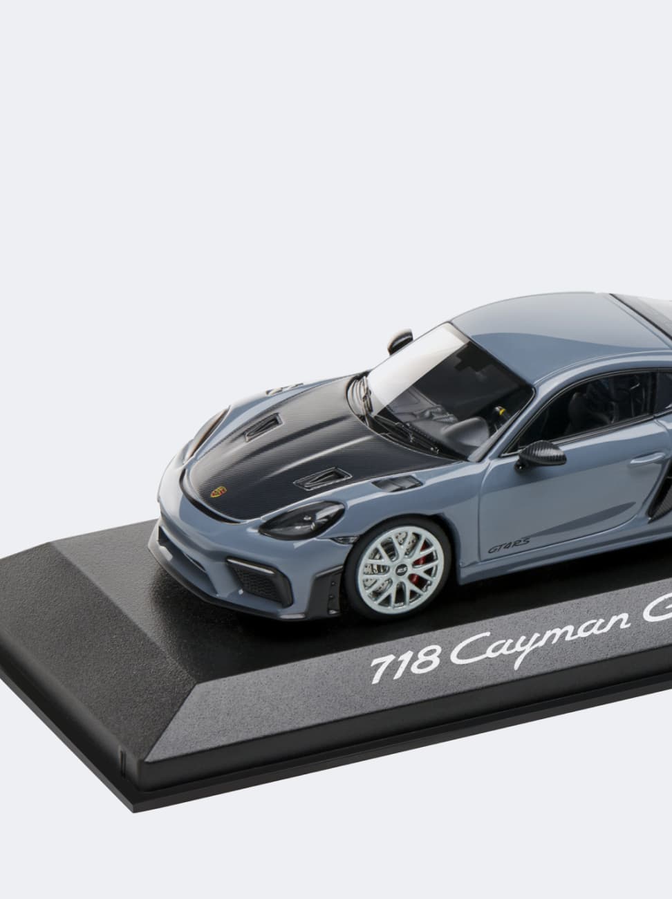 A Porsche 718 Cayman model car on a white background.