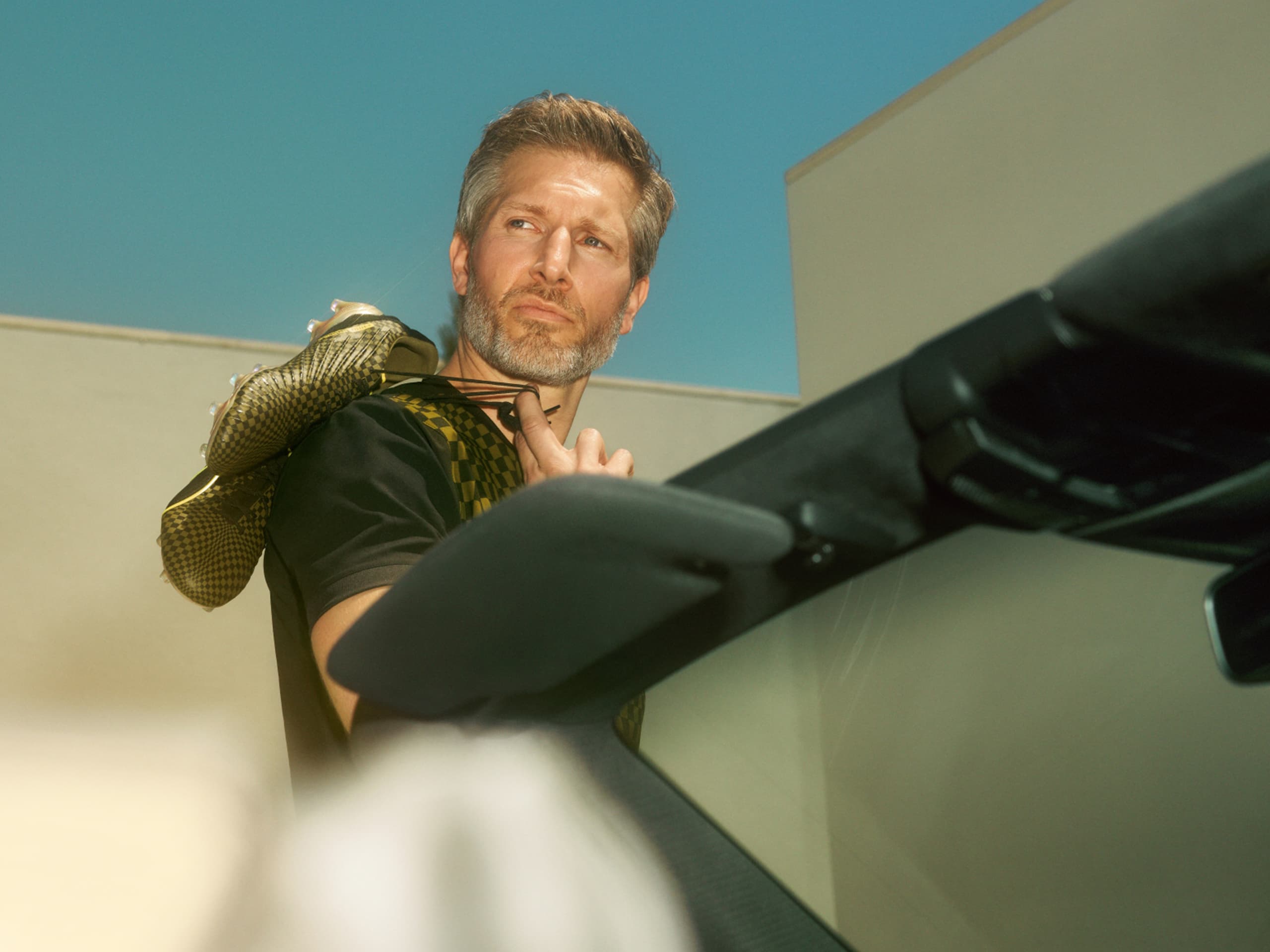 Man with Porsche soccer shoes over his shoulder.