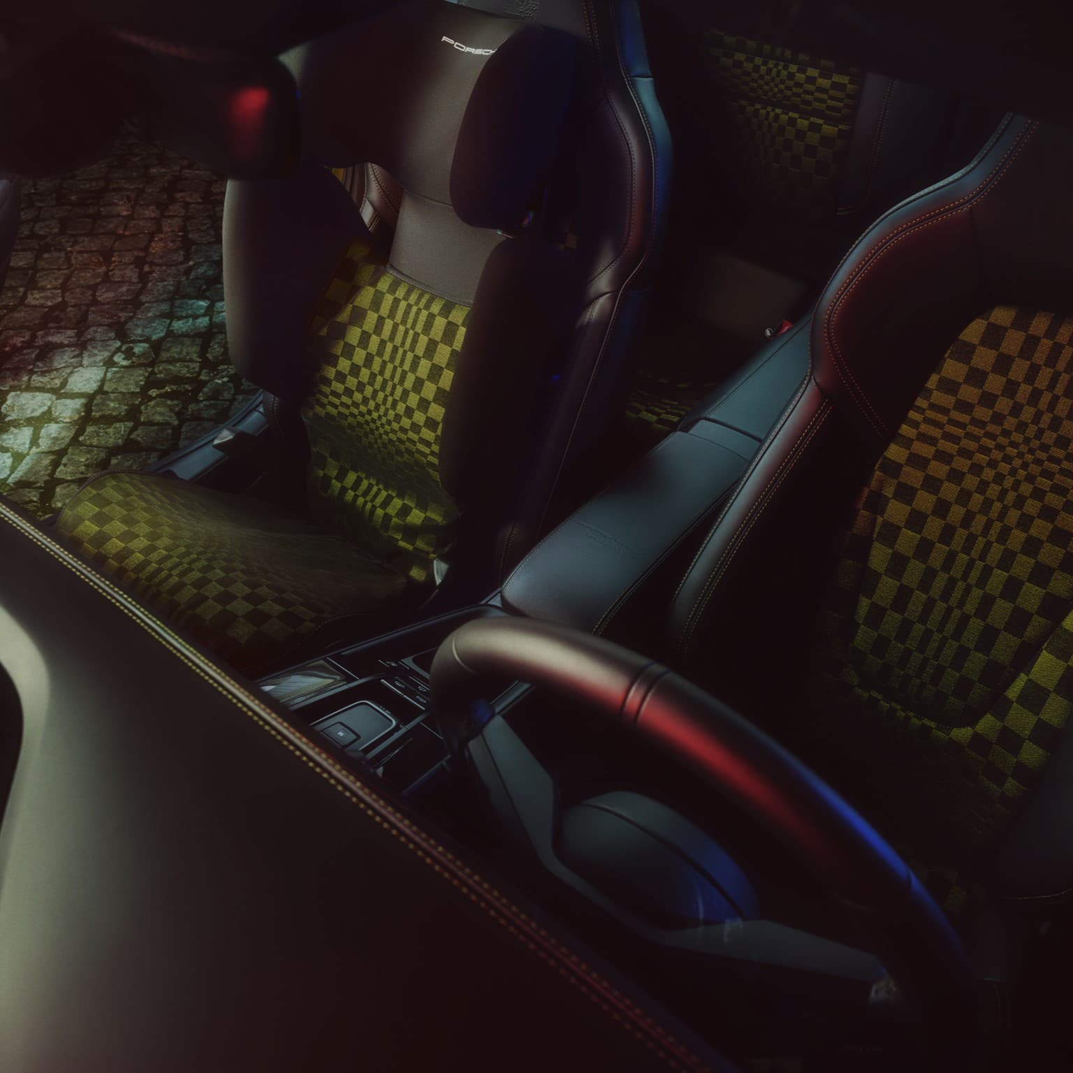 Innenraum eines Autos mit schwarzen Ledersitzen und grünem Karomuster, beleuchtet durch Umgebungslicht, Kopfsteinpflasterstraße draußen sichtbar.