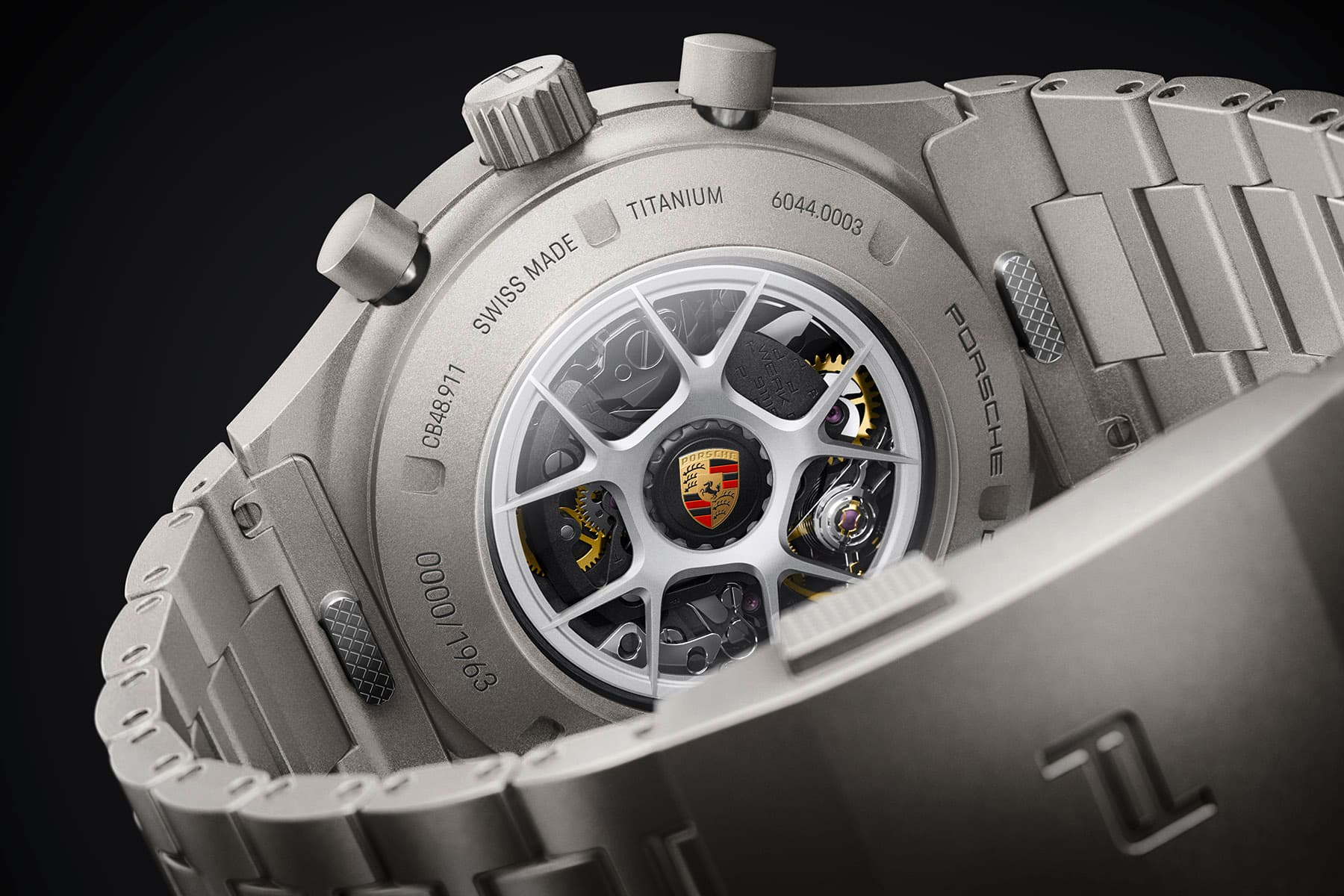Close-up of the back of a Porsche Titan wristwatch featuring a see-through case back, a rotor with a wheel-spoke design, and a metal bracelet.