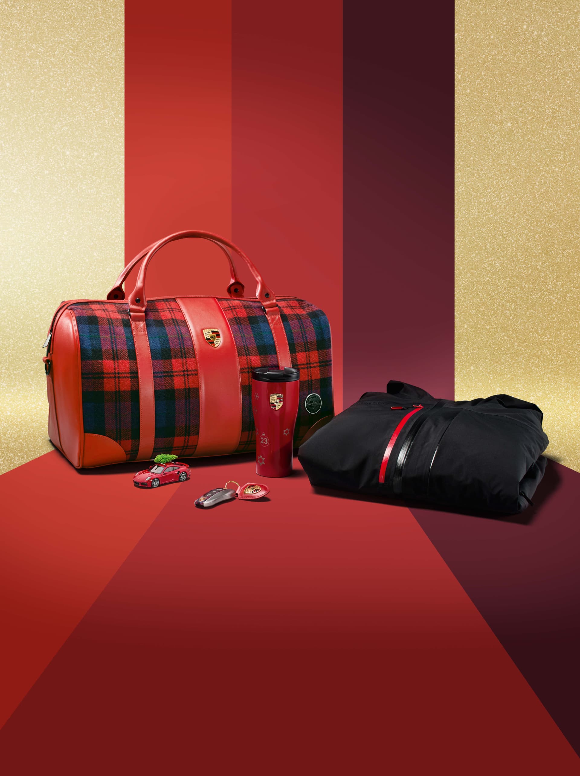 Red plaid bag, black jacket, red tumbler, toy car, and keychain on a red and gold striped background.
