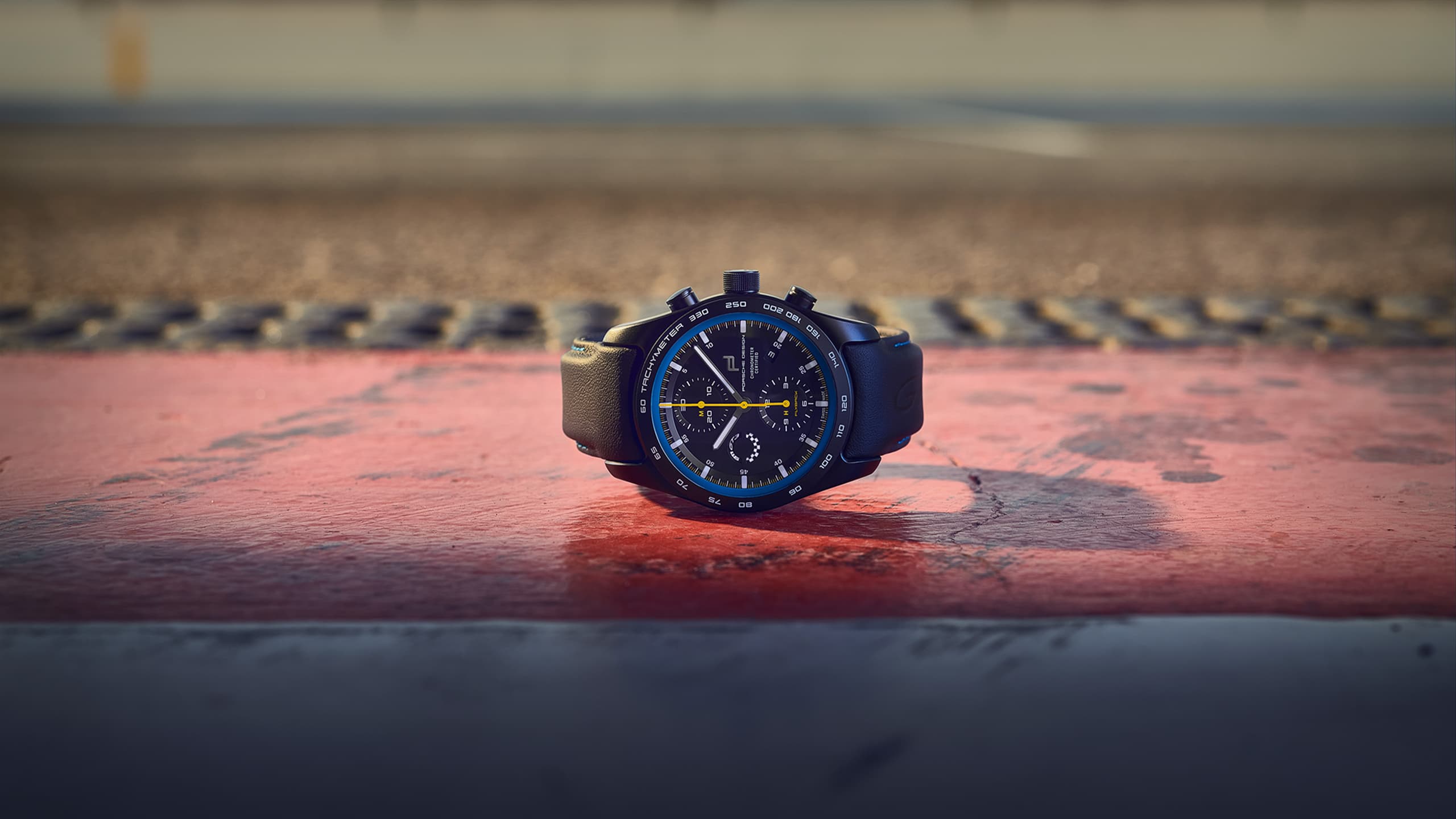 Na zdjęciu zegarek na rękę Porsche Chronograph 911 GT3, widok z przodu, na drodze.