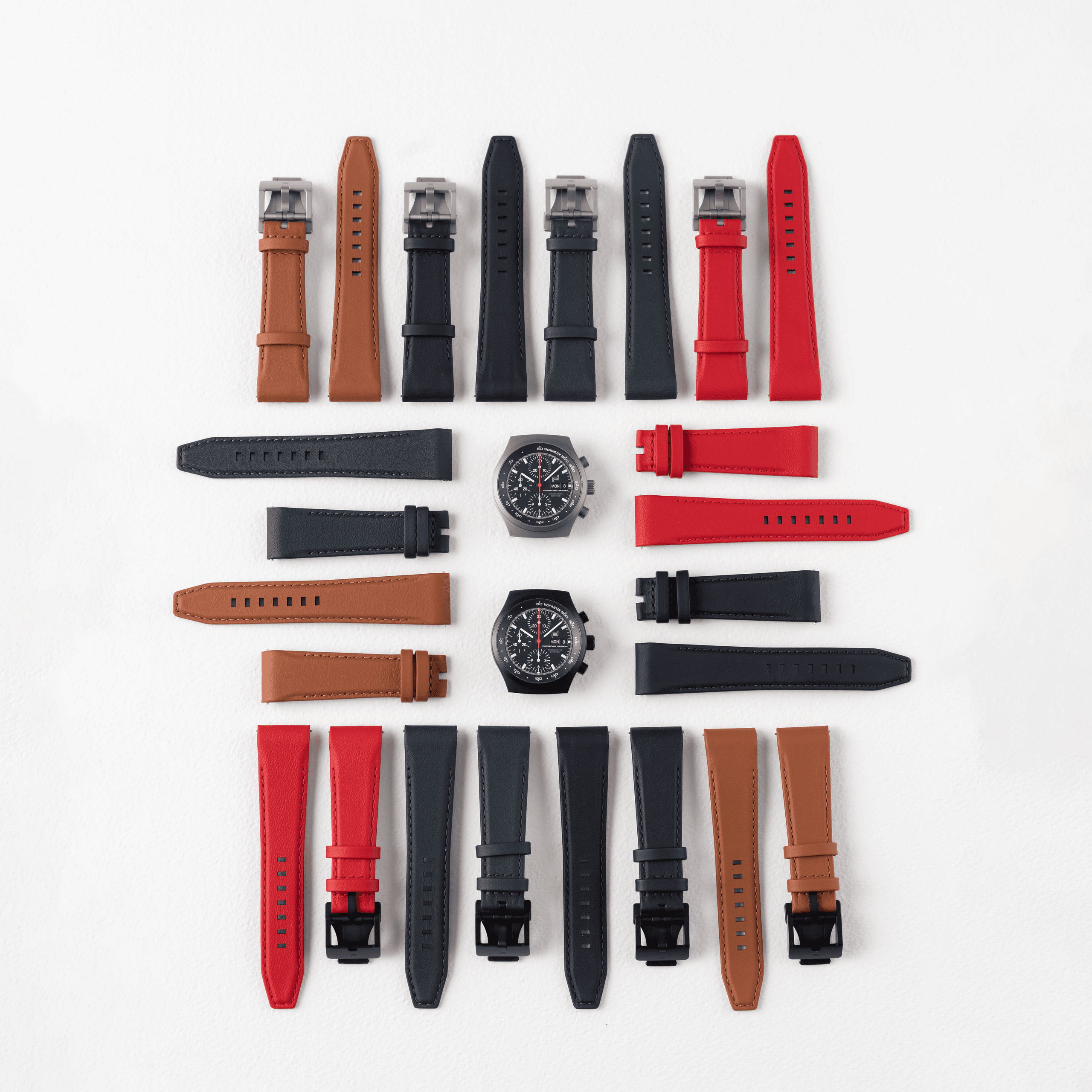 Verschiedene Lederarmbänder für Armbanduhren mit zwei Chronographen, auf weißem Hintergrund.