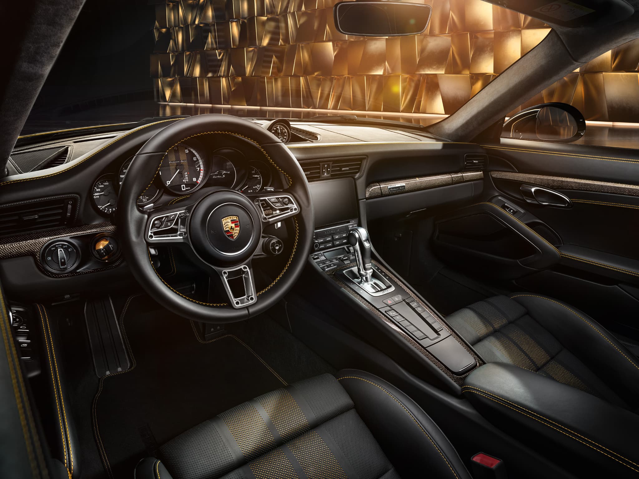 Wnętrze kokpitu Porsche z czarnymi skórzanymi fotelami, żółtymi przeszyciami, kierownicą i konsolą środkową, złote tło na zewnątrz
