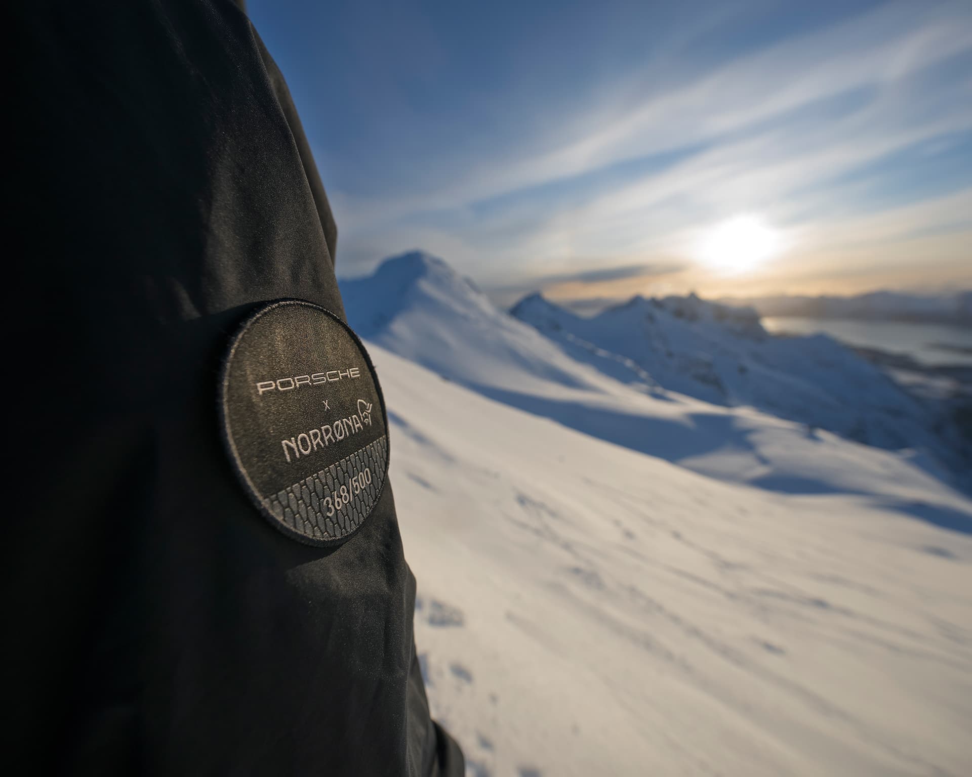detail shot of Logo of the Porsche x Norrøna Ski Collection, mountains in the back
