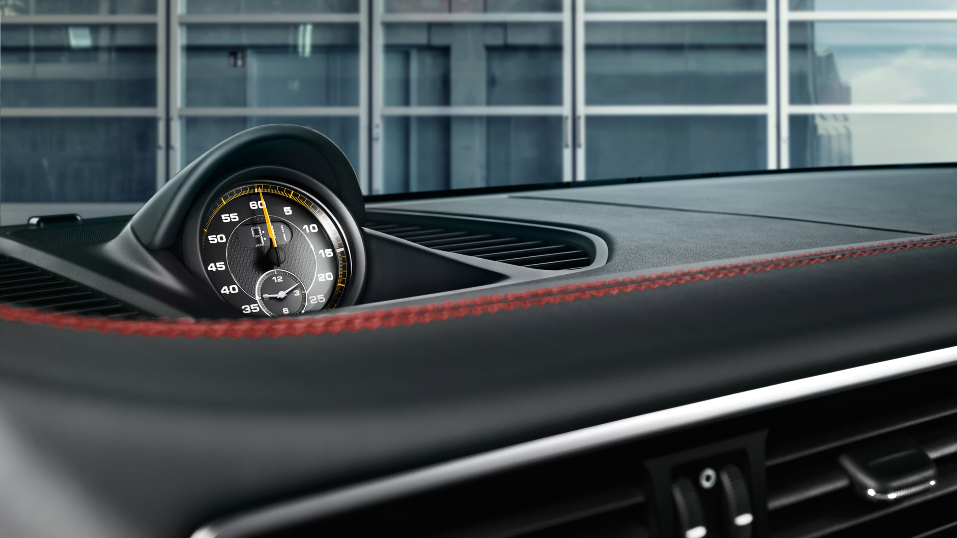 Shown is an analog clock or chronograph in the center of the dashboard of the Porsche GT2 RS