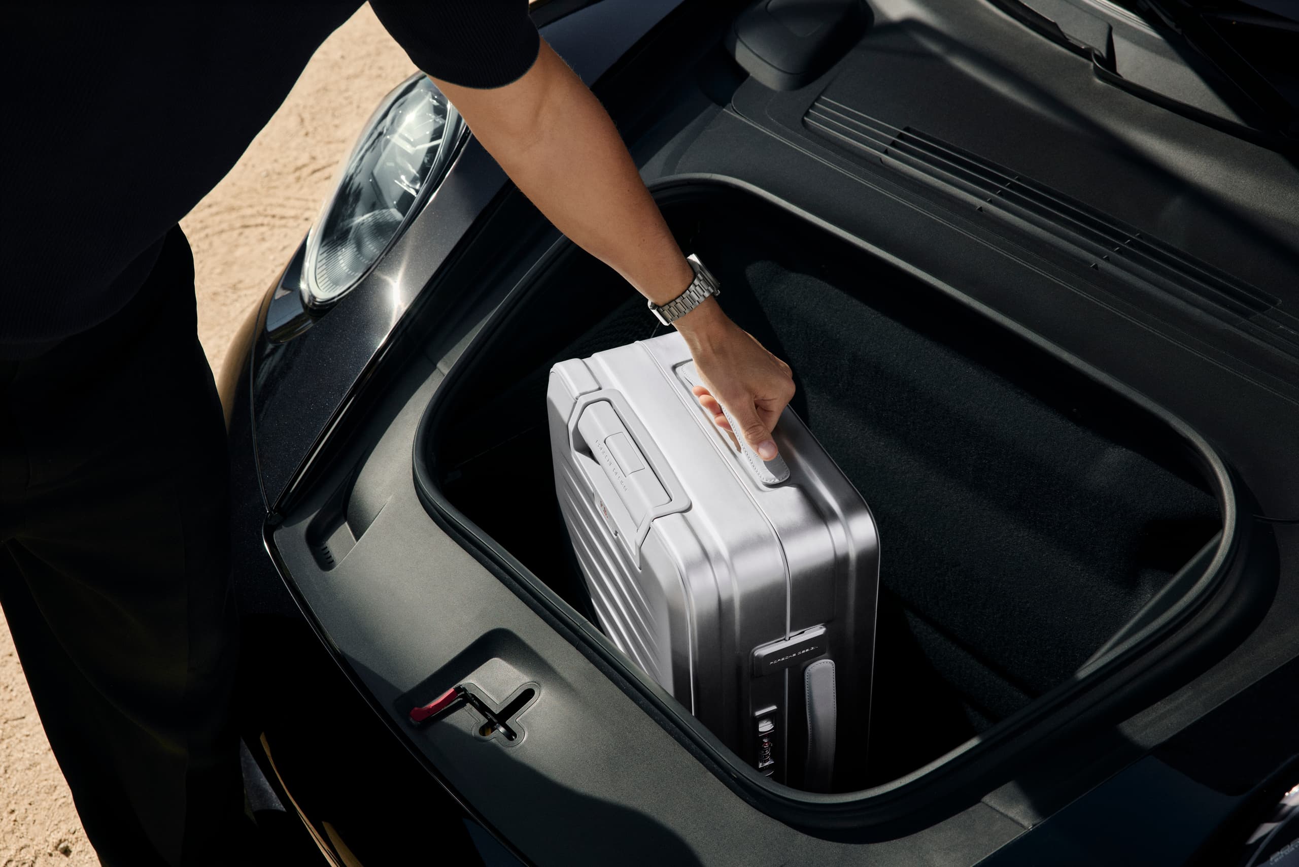 Man putting the Roadster Aluminum Trolley in a Porsche 911 Targa trunk