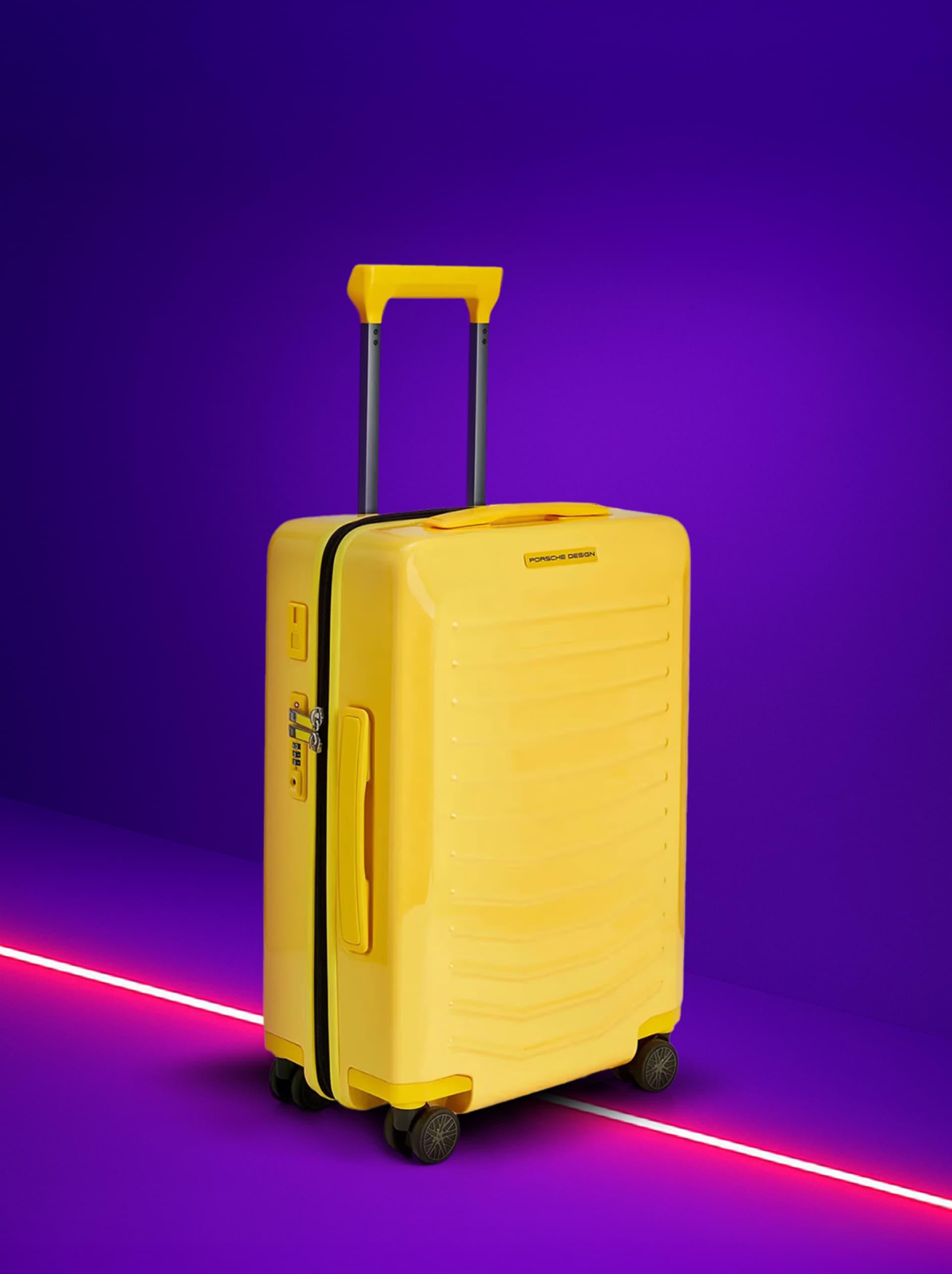 Yellow suitcase with telescopic handle on purple background, featuring Porsche Design logo.