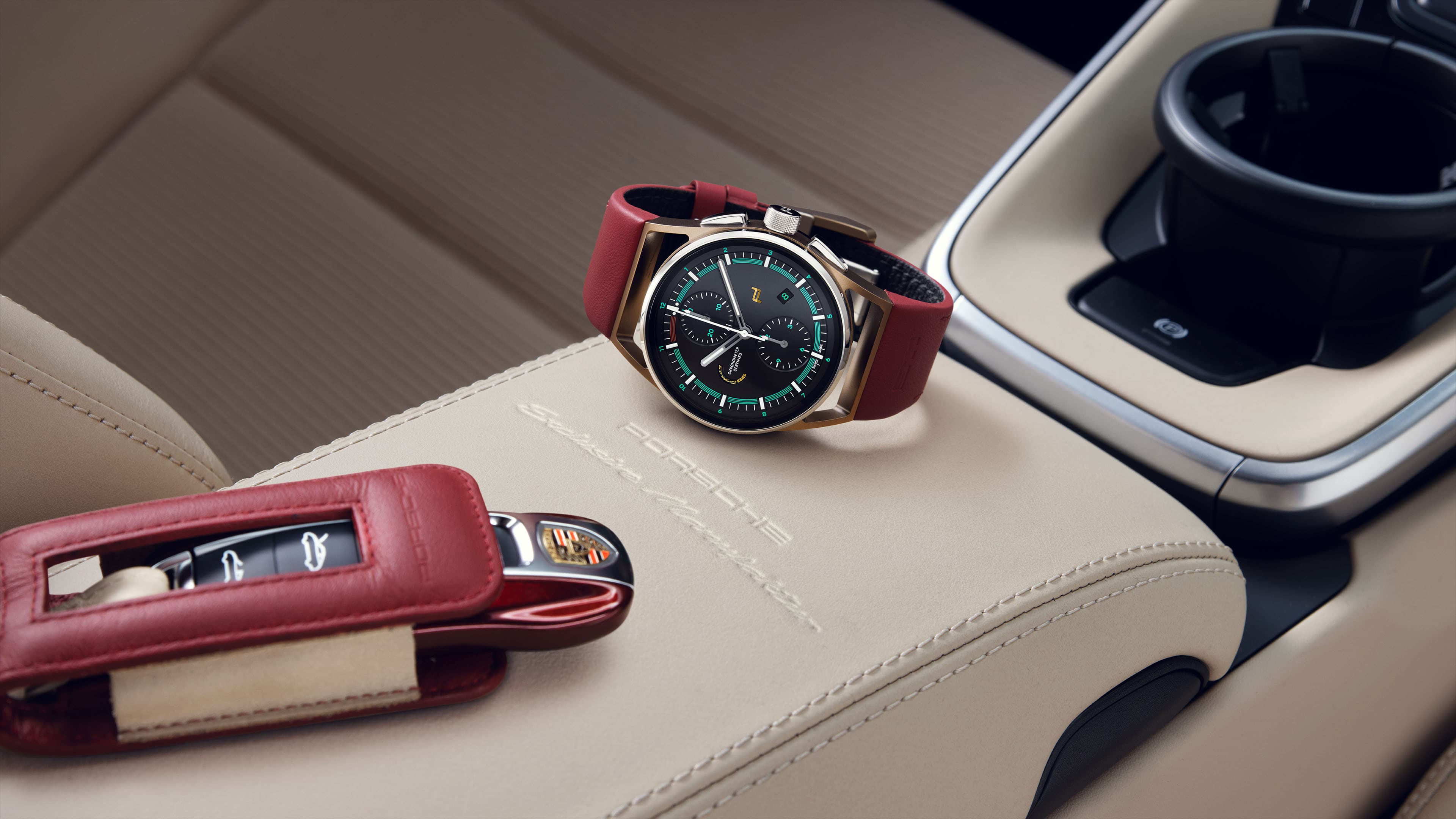 Abgebildet ist die Chronograph 911 Targa 4S Heritage Design Edition mit rotem Armband und einem Porsche Autoschlüssel auf beigem Lederhintergrund im Innenraum eines Porsche.