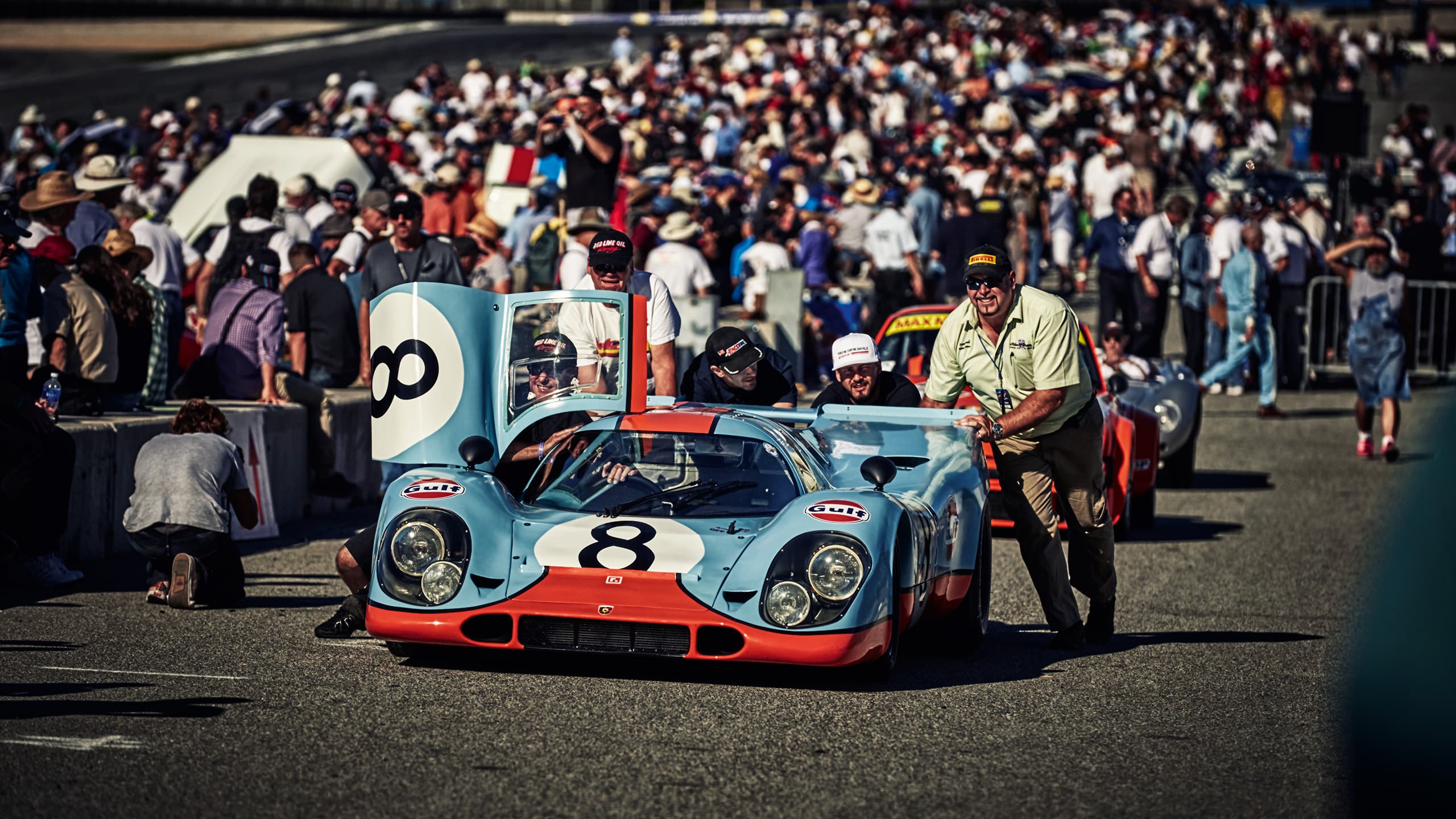 Porsche racing car on a race track with spectators.