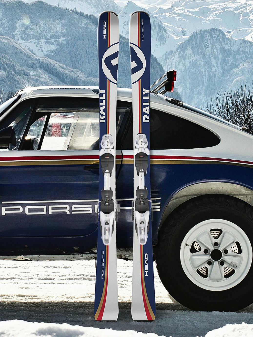A pair of new Porsche HEAD Ski 8 Series Rally Skis pictured leaning against the side of a Porsche 911 in Rally livery, with mountains in the background.