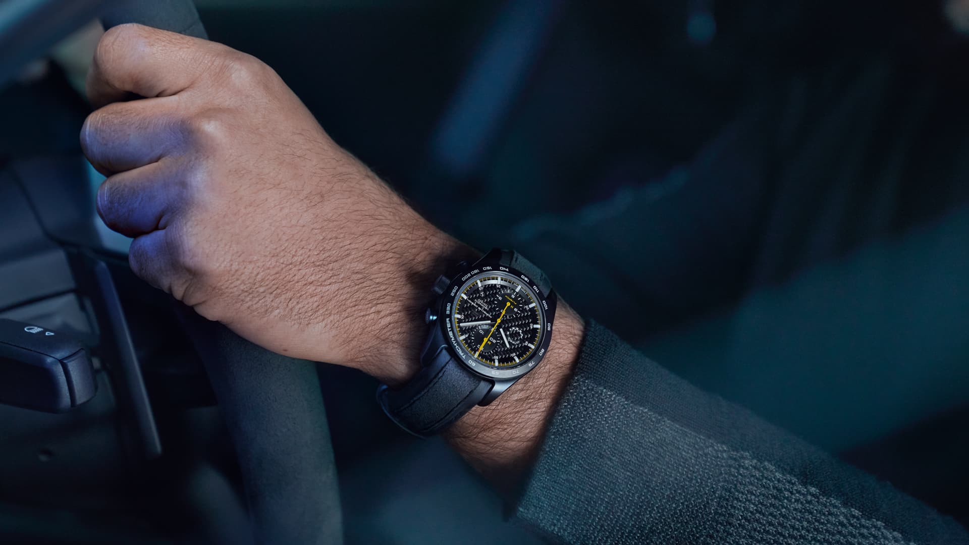 Abgebildet ist ein Mann, der die Porsche Armbanduhr Chronograph 718 Cayman GT4 RS trägt.