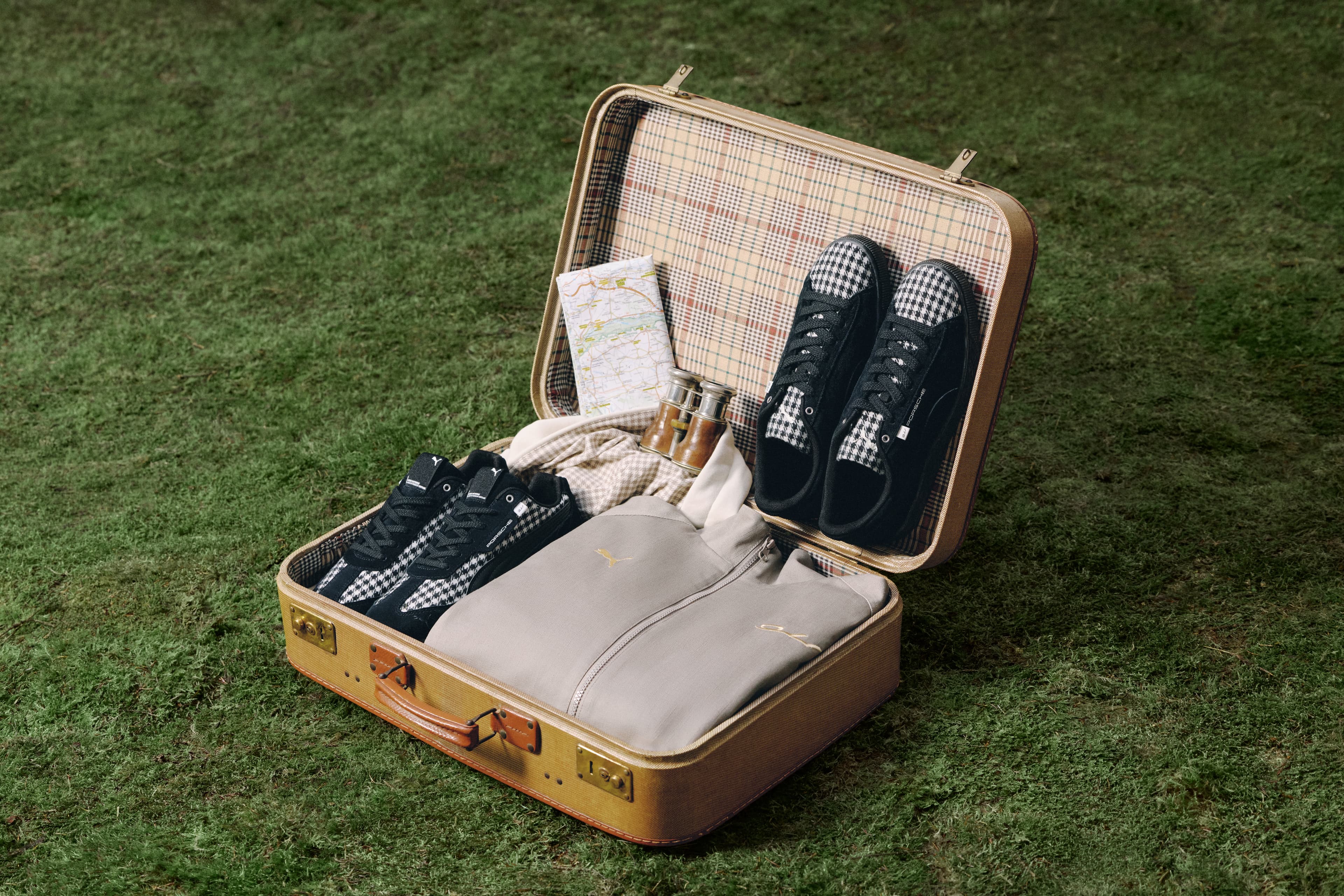 Open suitcase with new items from the Legacy x Pepita Porsche collection