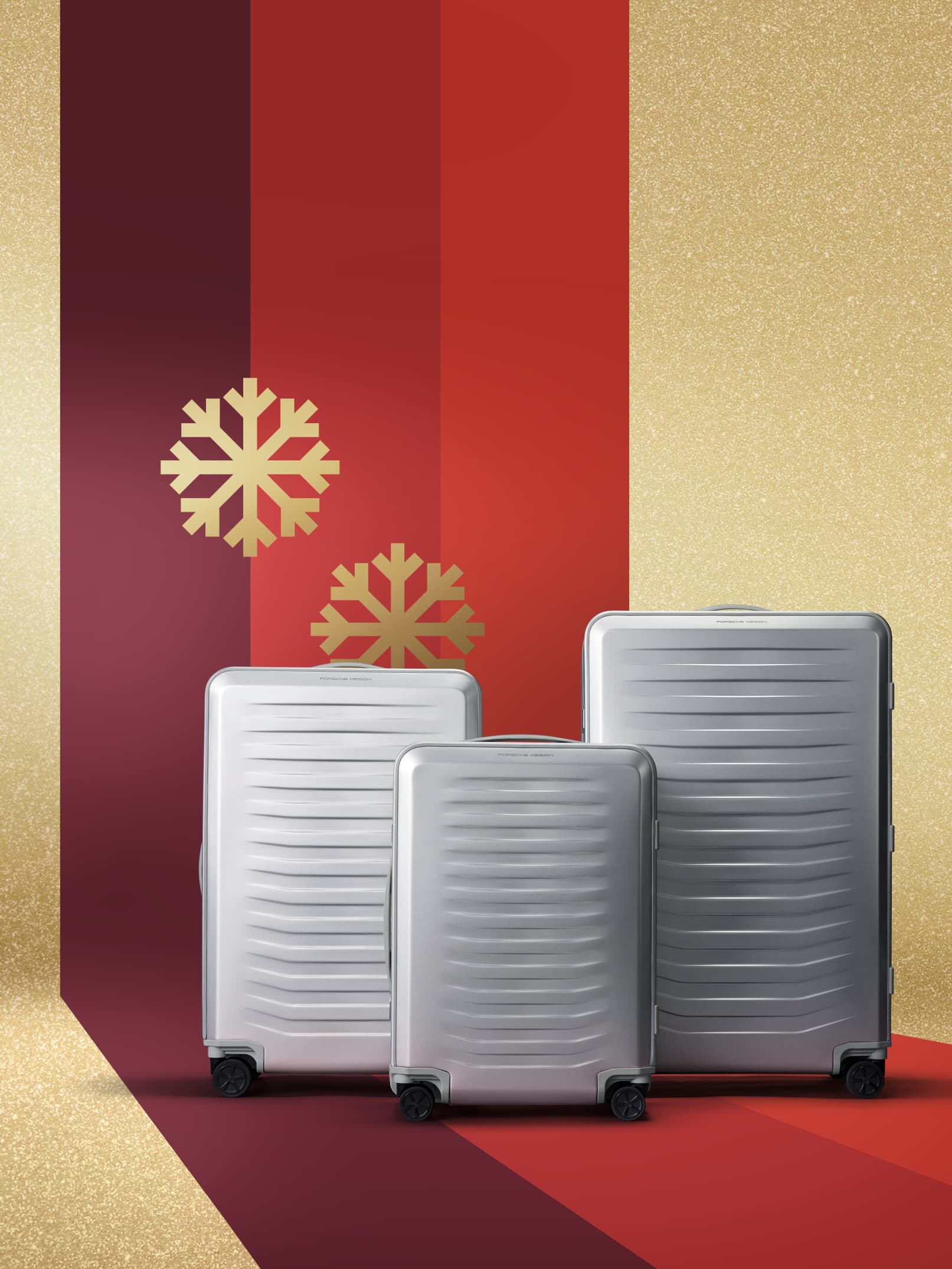 Three silver suitcases on a red and gold background with gold snowflakes, conveying a festive holiday theme.