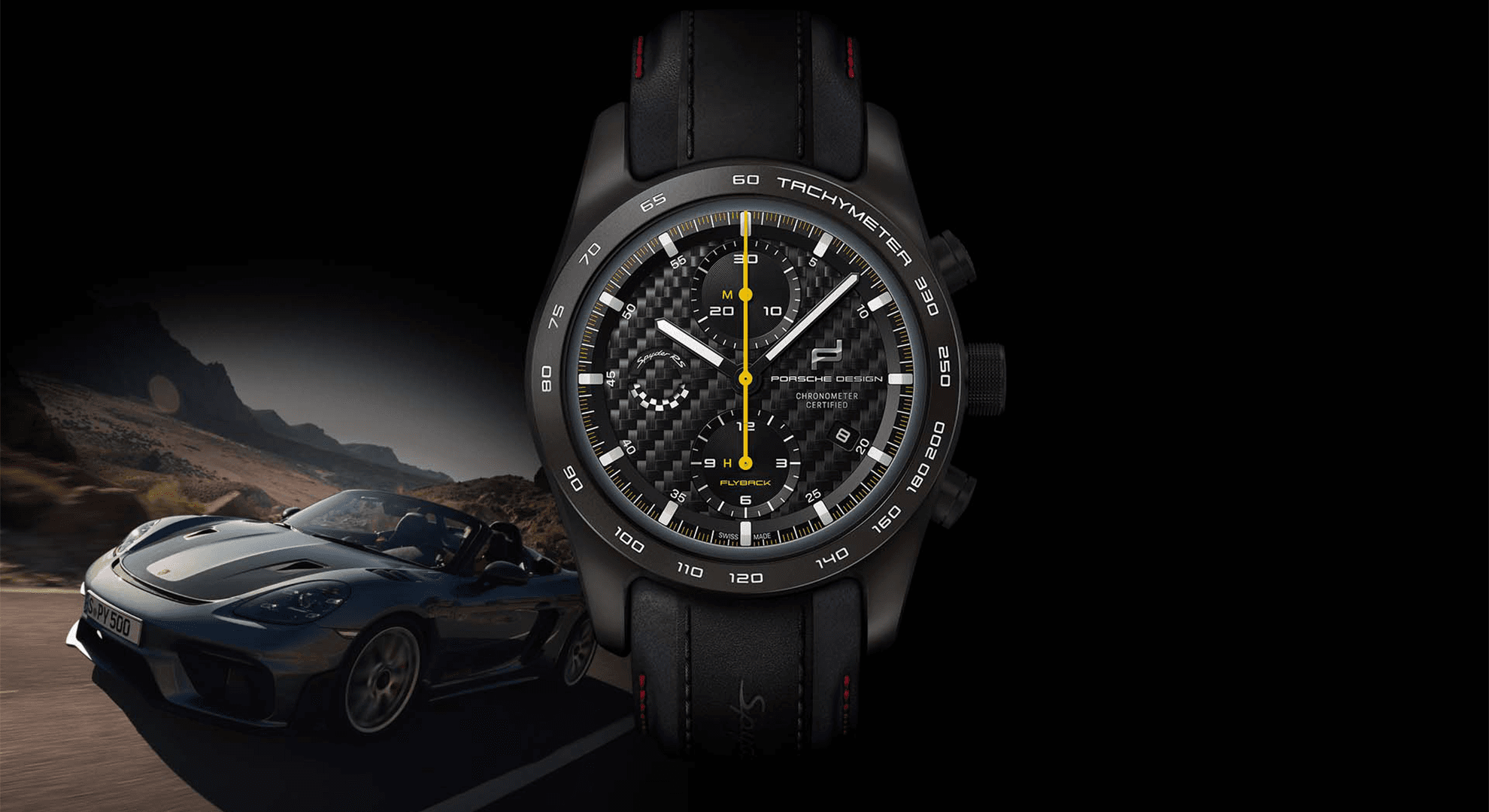 Black Porsche Design chronograph with a carbon dial and a yellow seconds hand, alongside a convertible on the road at dusk
