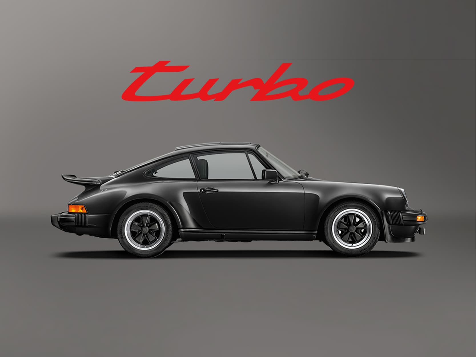 Black historic Porsche 911 on a green background with a red Turbo lettering above the car