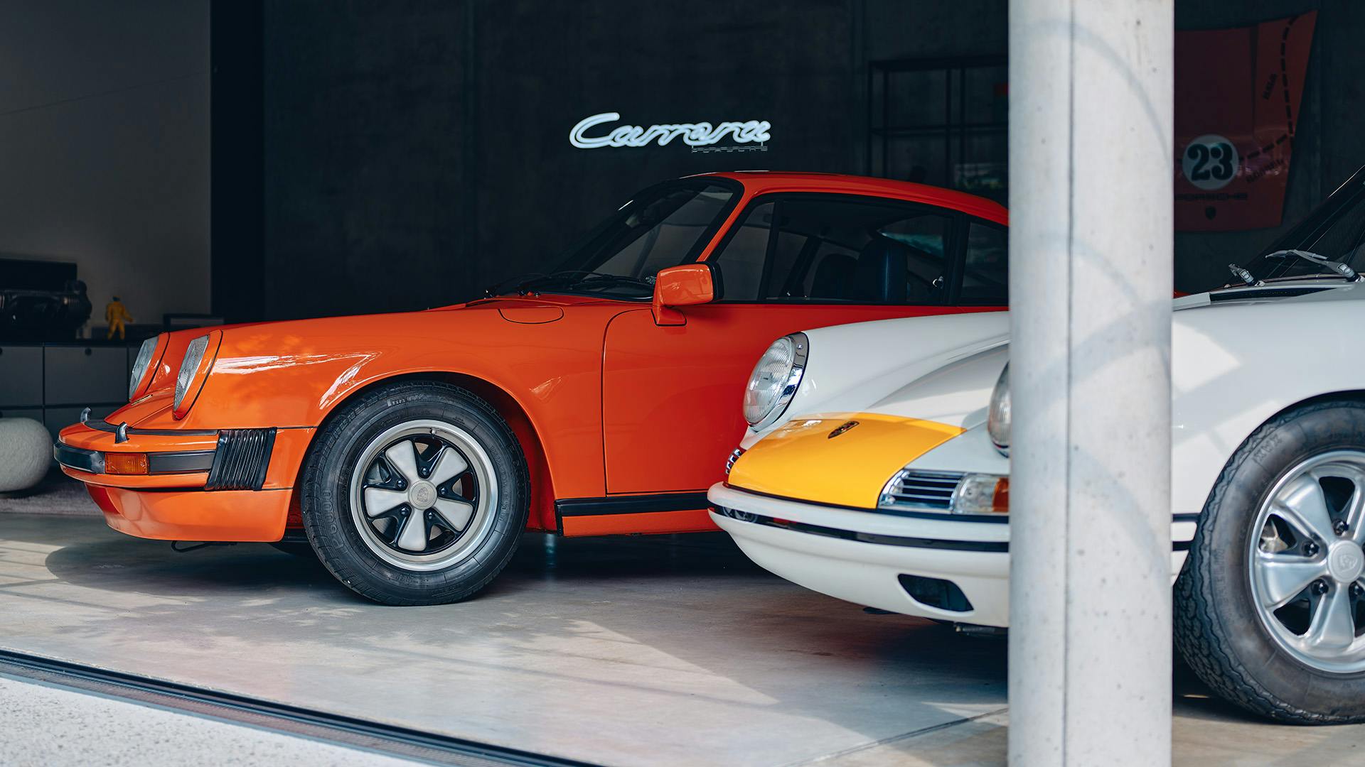 Shown are two oldtimer Porsche in the color orange and white-yellow in a soul garage.