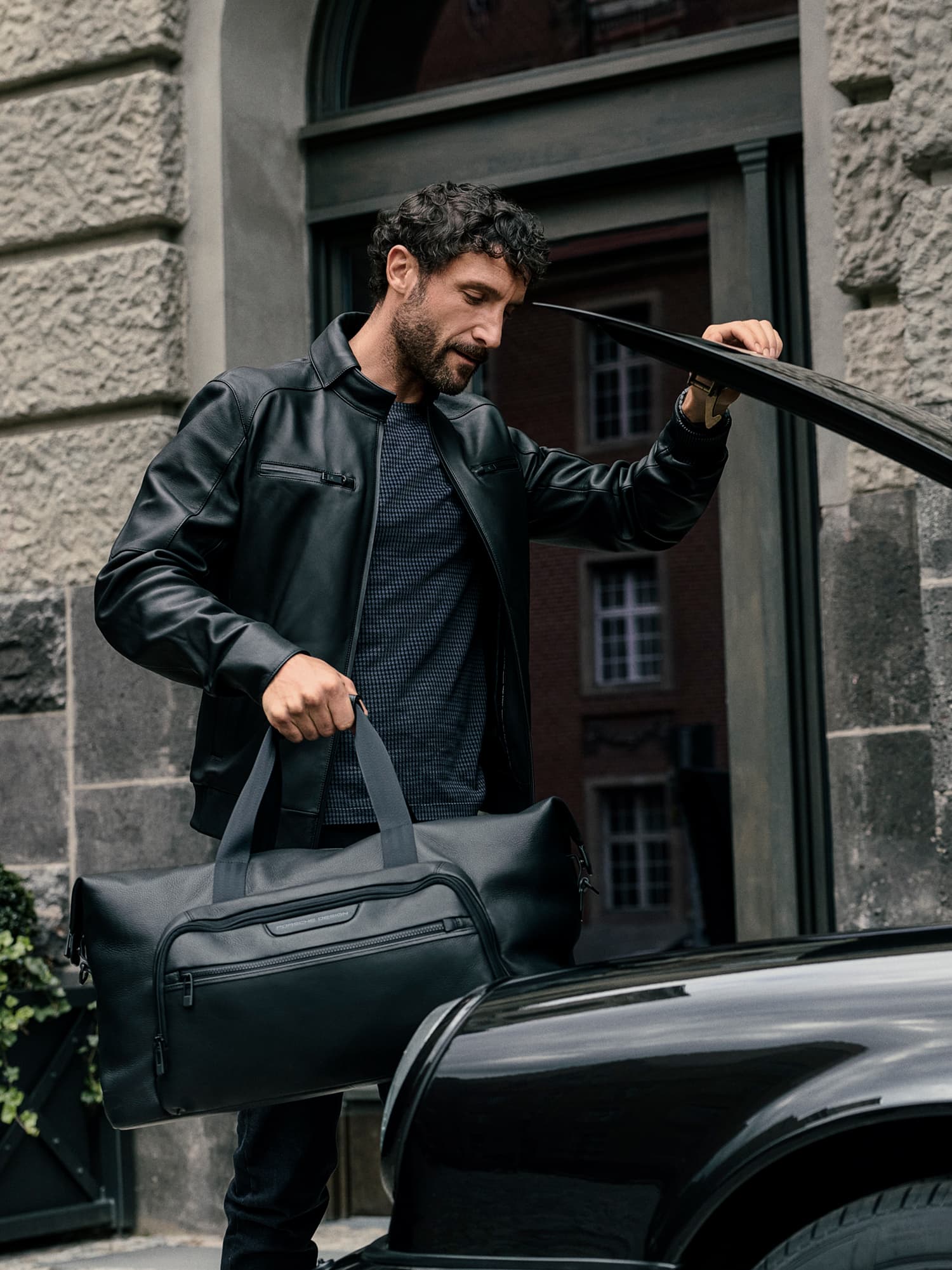 Dwóch mężczyzn niosących bagaż Porsche Design