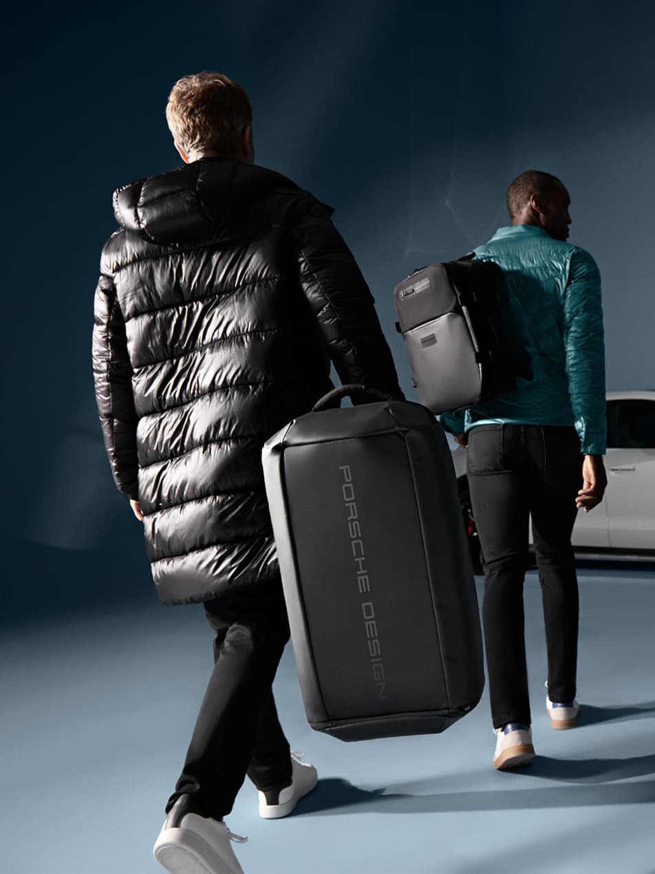 Two men carrying Porsche Design Luggage