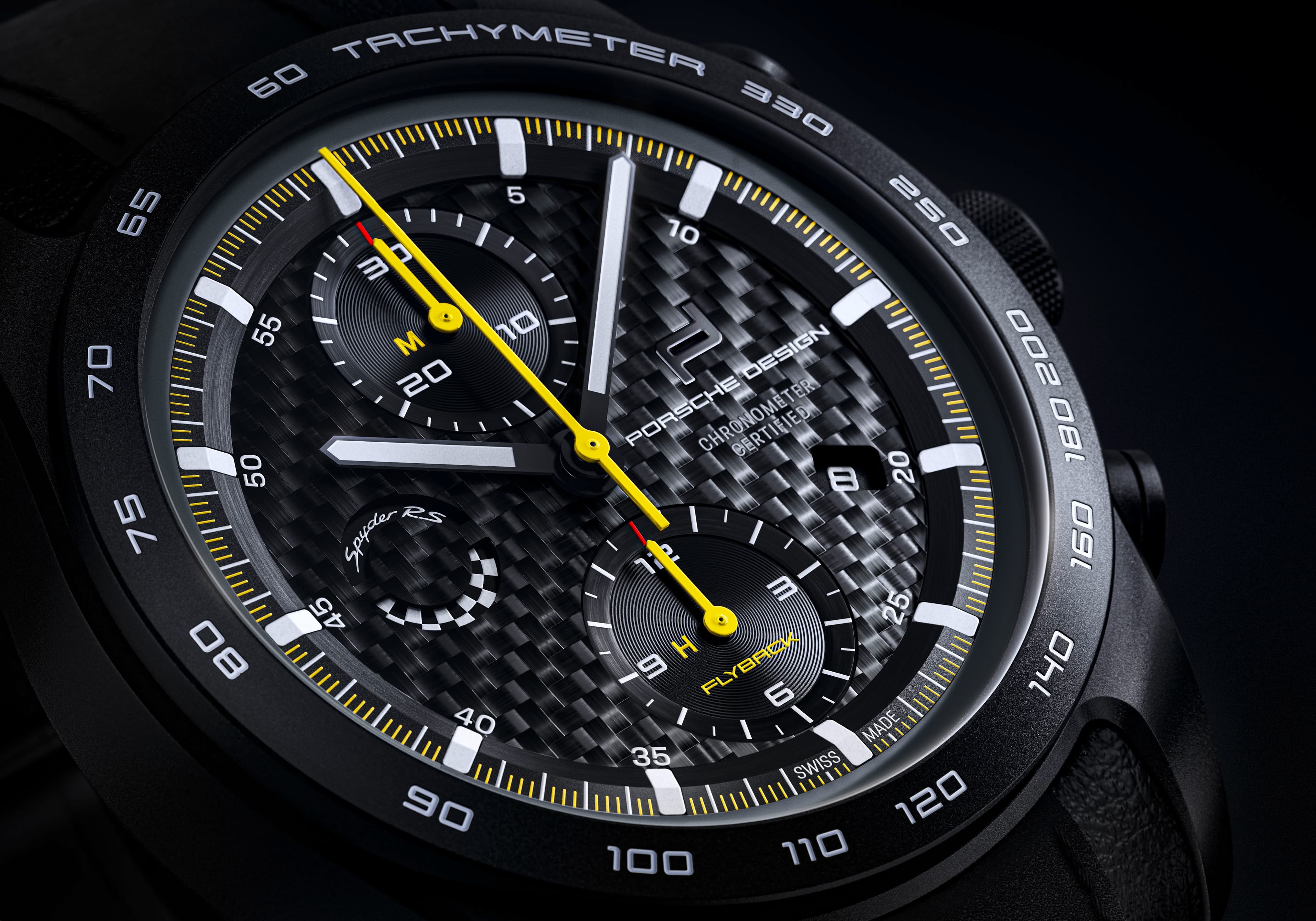 Close-up of a Porsche Design chronograph with a carbon dial, yellow hands, and a black tachymeter bezel