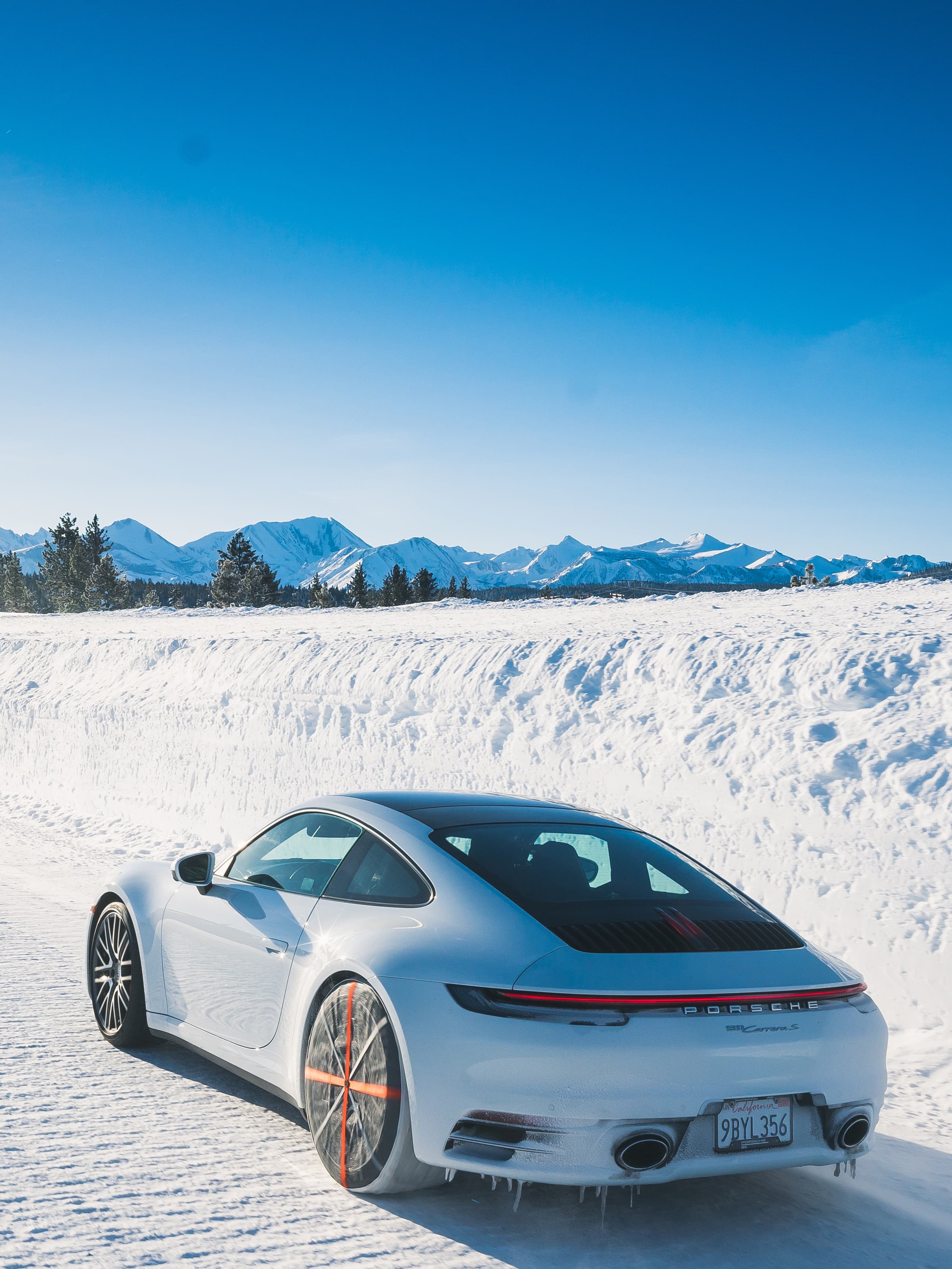 Pictured is a Porsche 911 from behind in the snow.