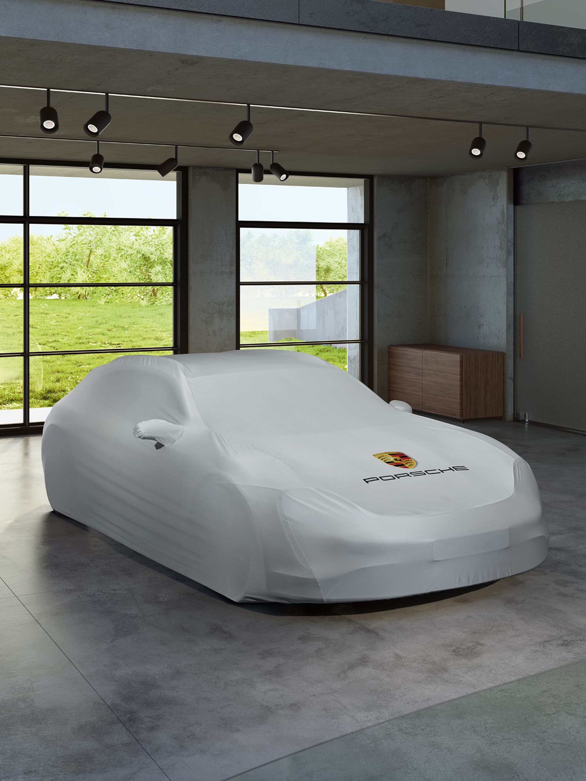 You can see a car beneath a Porsche car cover in a garage