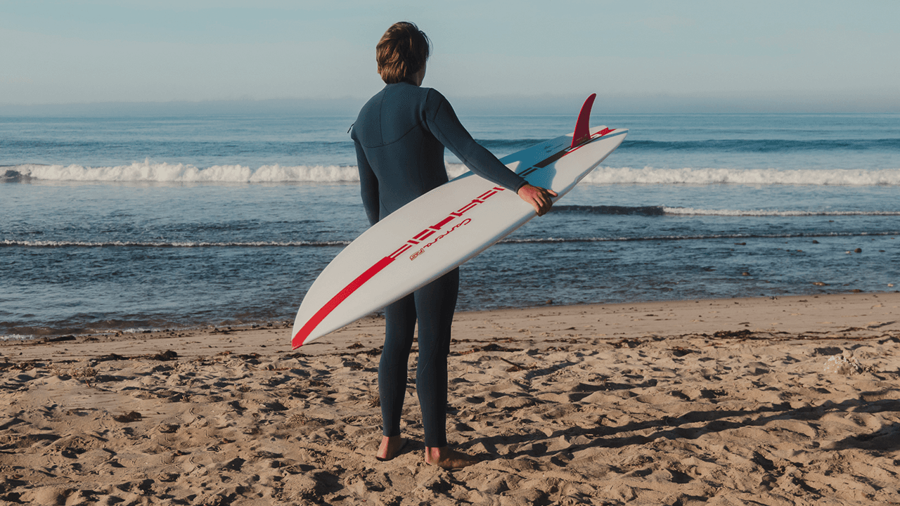 Man standing on Beach with Surfboard