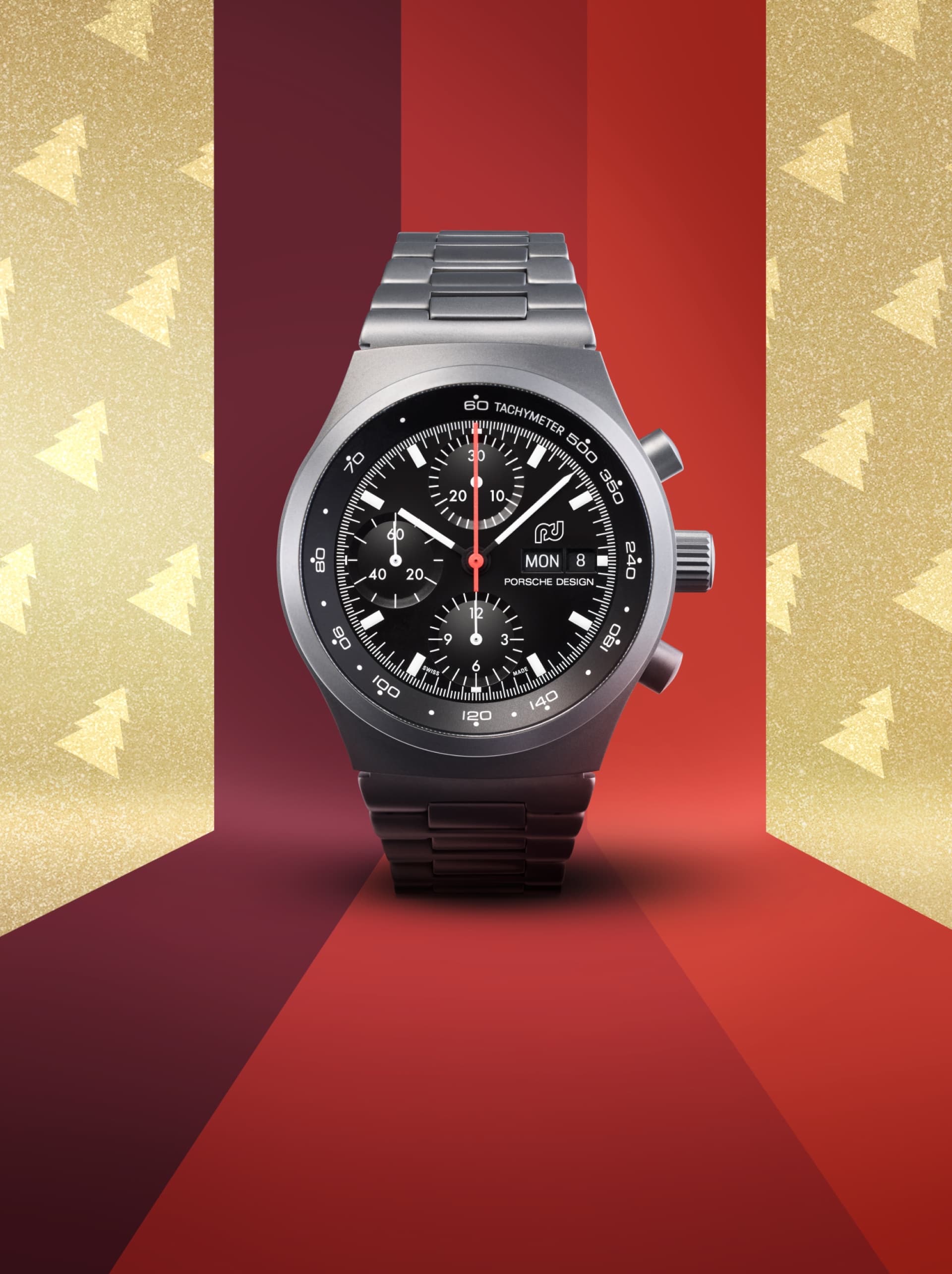 Montre Porsche Timepieces noire sur fond rouge et doré avec sapins de Noël dorés.