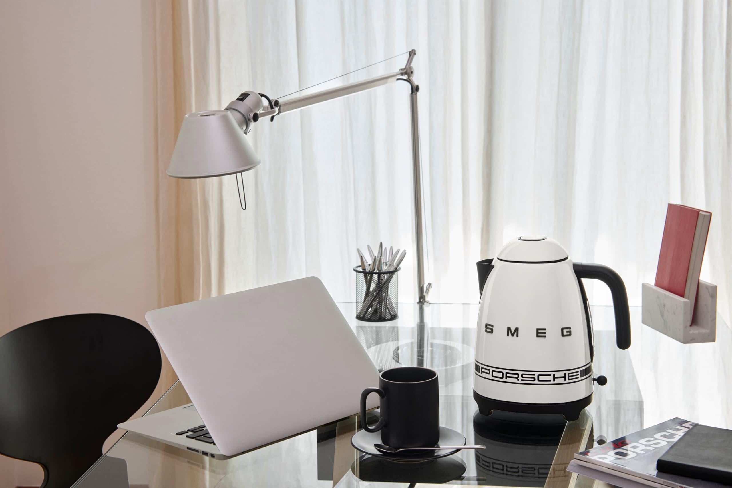 Porsche x Smeg kettle in Carrara White on a workstation table in a business scenario
