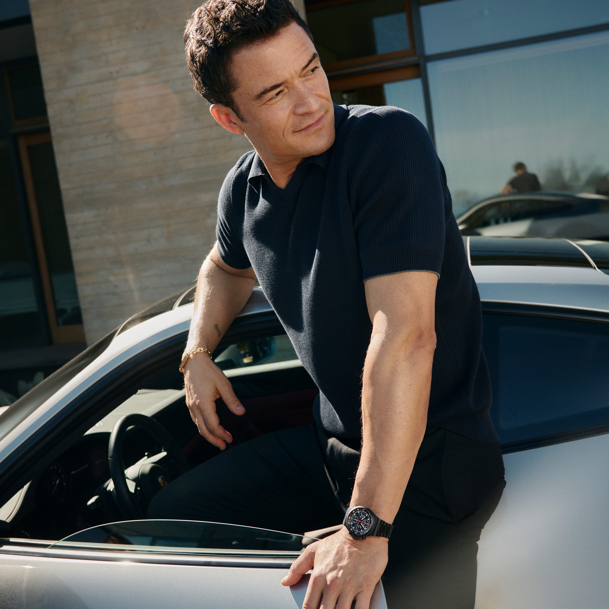 Orlando Bloom ma na nadgarstku Chronograph 1 – All Black Numbered Edition i wsiada do swojego Porsche