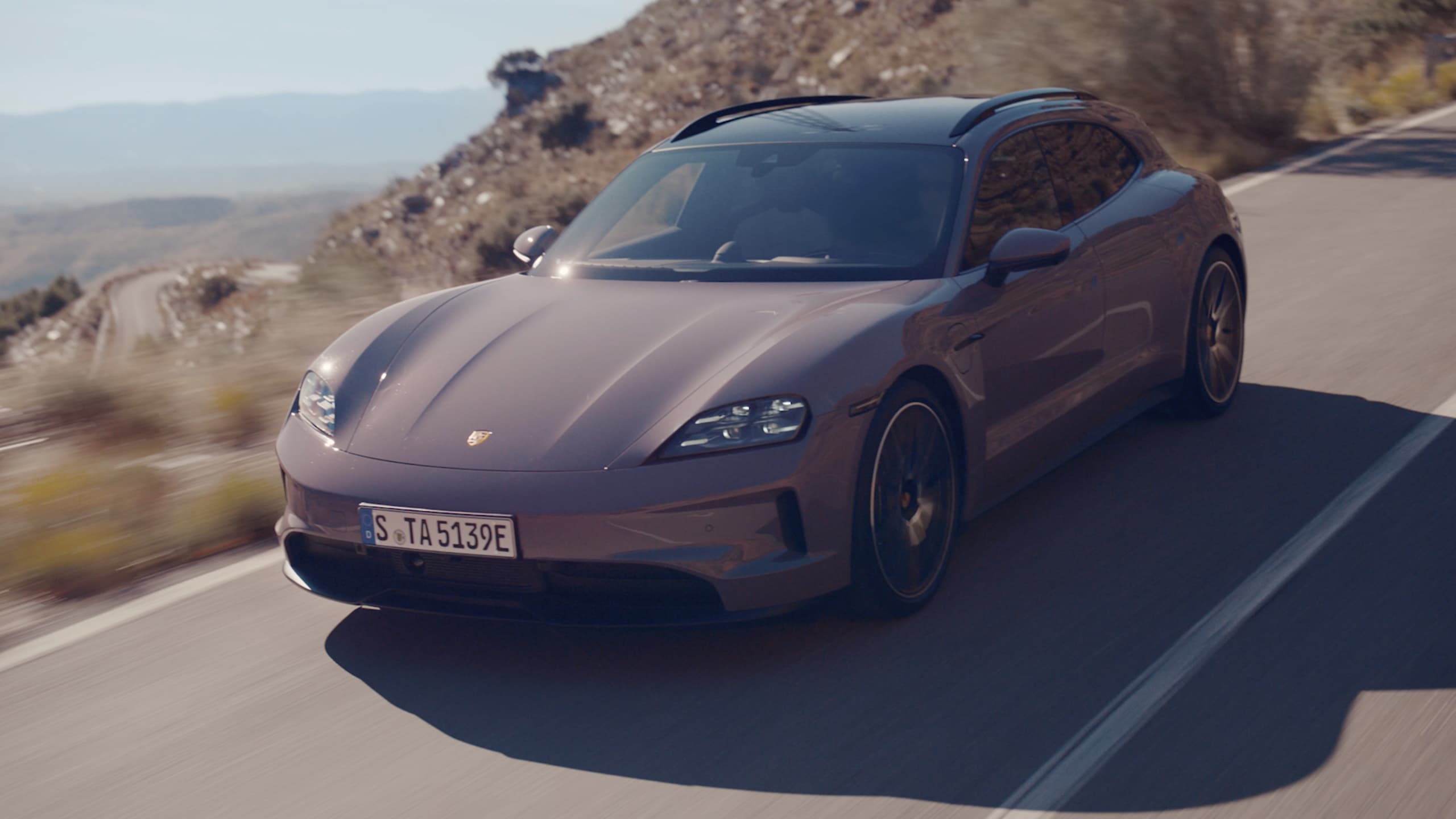 Purple coloured Porsche Taycan on a road